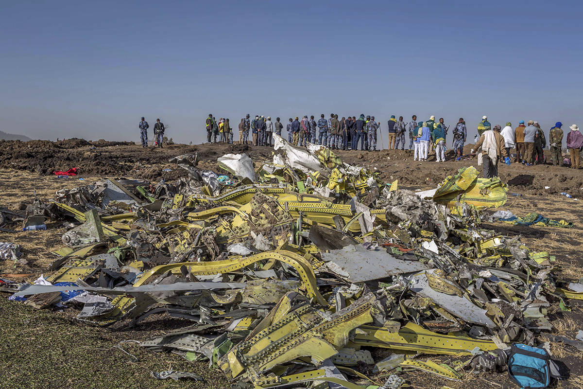 FILE - In this March 11, 2019, file photo, wreckage is piled at the crash scene of Ethiopian Airlines flight ET302 near Bishoftu, Ethiopia. The year since the crash of an Ethiopian Airlines Boeing 737 Max has been a journey through grief, anger and determination for the families of those who died, as well as having far-reaching consequences for the aeronautics industry as it brought about the grounding of all Boeing 737 Max 8 and 9 jets, which remain out of service. (AP Photo/Mulugeta Ayene, File)