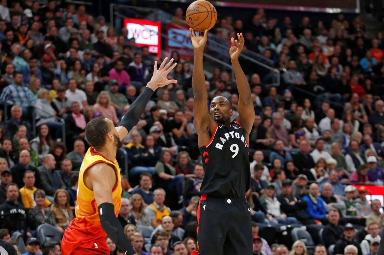 Toronto Raptors centre Serge Ibaka (9) shoots as Utah Jazz centre Rudy Gobert, left, defends In the first half of an NBA basketball game, Monday, March 9, 2020, in Salt Lake City. All Toronto Raptors players, coaches and travelling staff have been advised to go into self-isolation for 14 days. THE CANADIAN PRESS/AP/Rick Bowmer