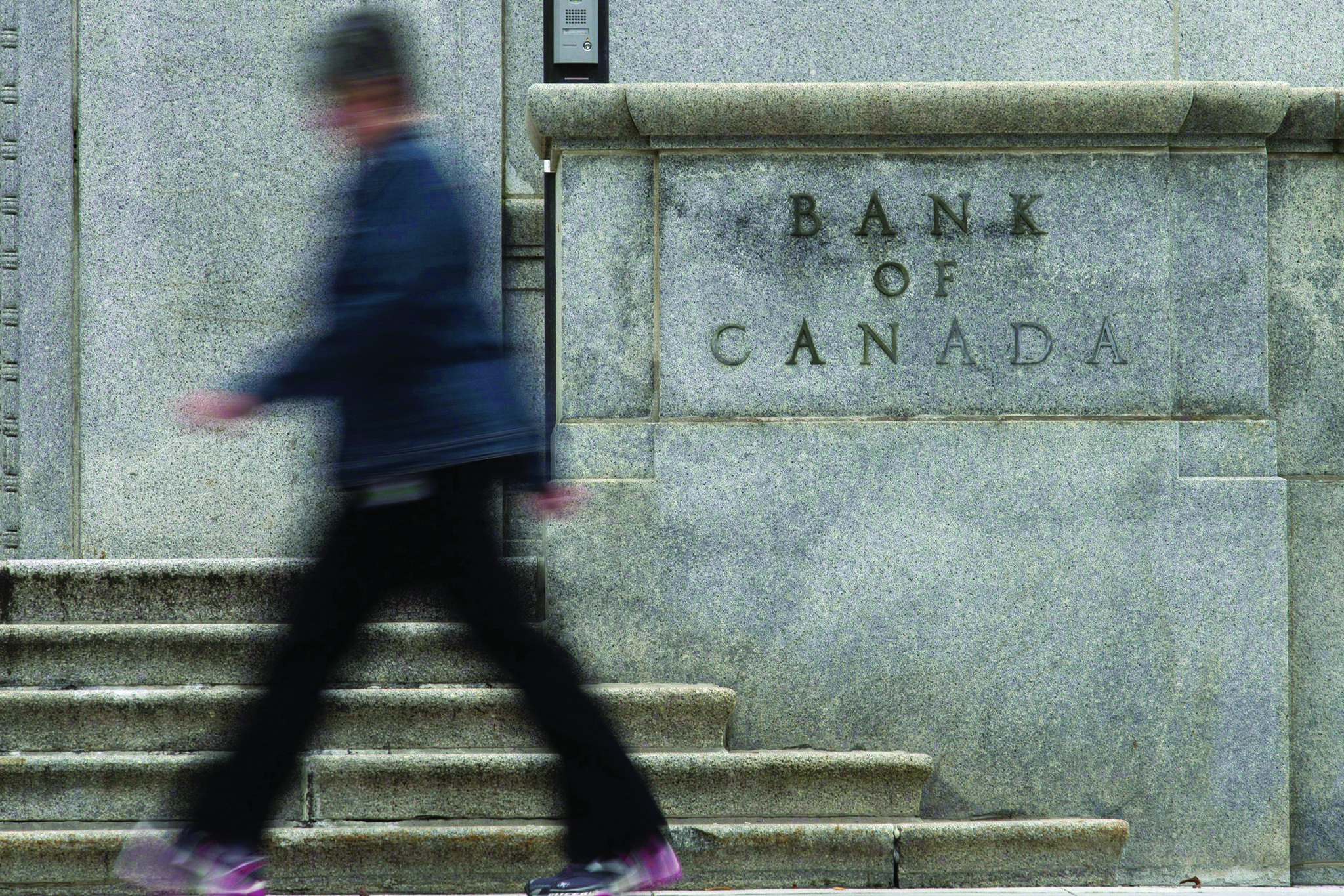 A woman walks past the Bank of Canada in Ottawa. File photo by THE CANADIAN PRESS