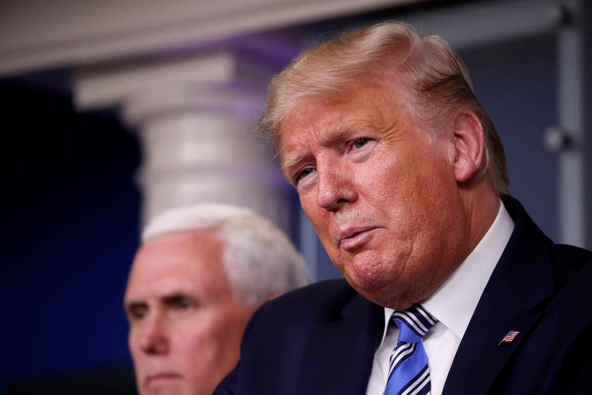 President Donald Trump and Vice President Mike Pence listen during a briefing about the coronavirus in the James Brady Briefing Room, Monday, March 23, 2020, in Washington. (AP Photo/Alex Brandon)