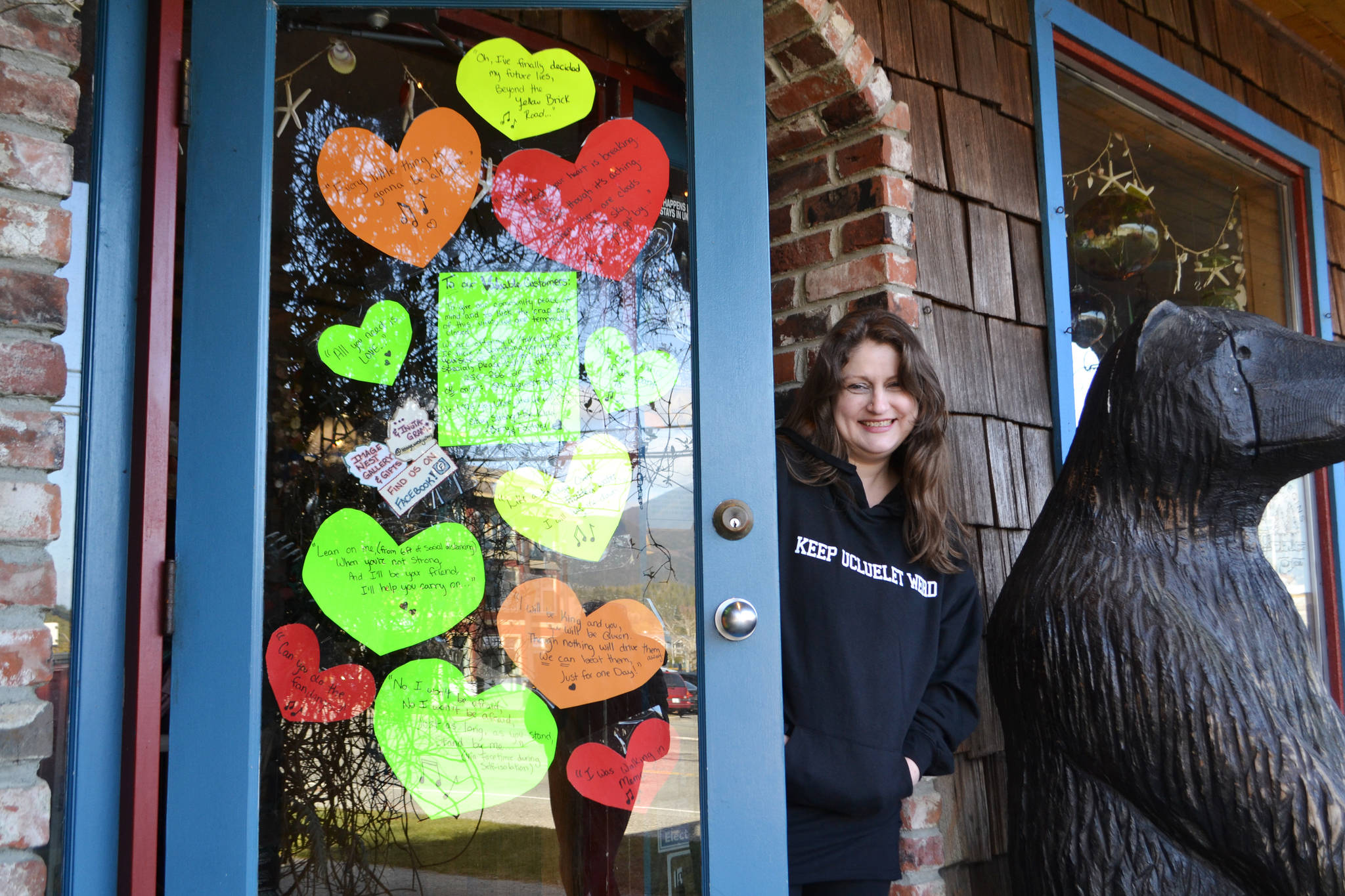 Image West Gallery co-owner Courtney Johnson lends a smile beside her melodious door collage of hearts. As of March 20, the Ucluelet gift shop that has been in business for 30 years closed indefinitely. (Nora O’Malley photo)