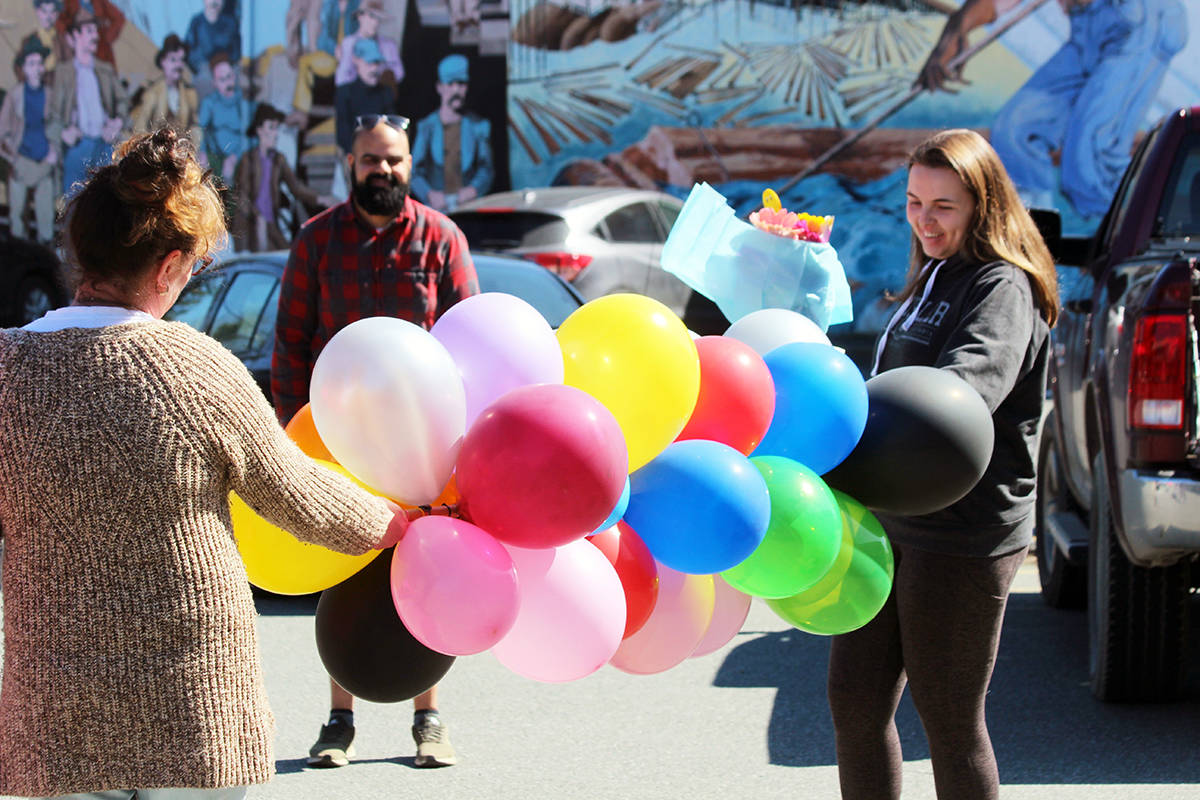 Jacquie McLeod with a balloon broom for Ryan Cheema and Holly Douglas. (Photo by Don Bodger)