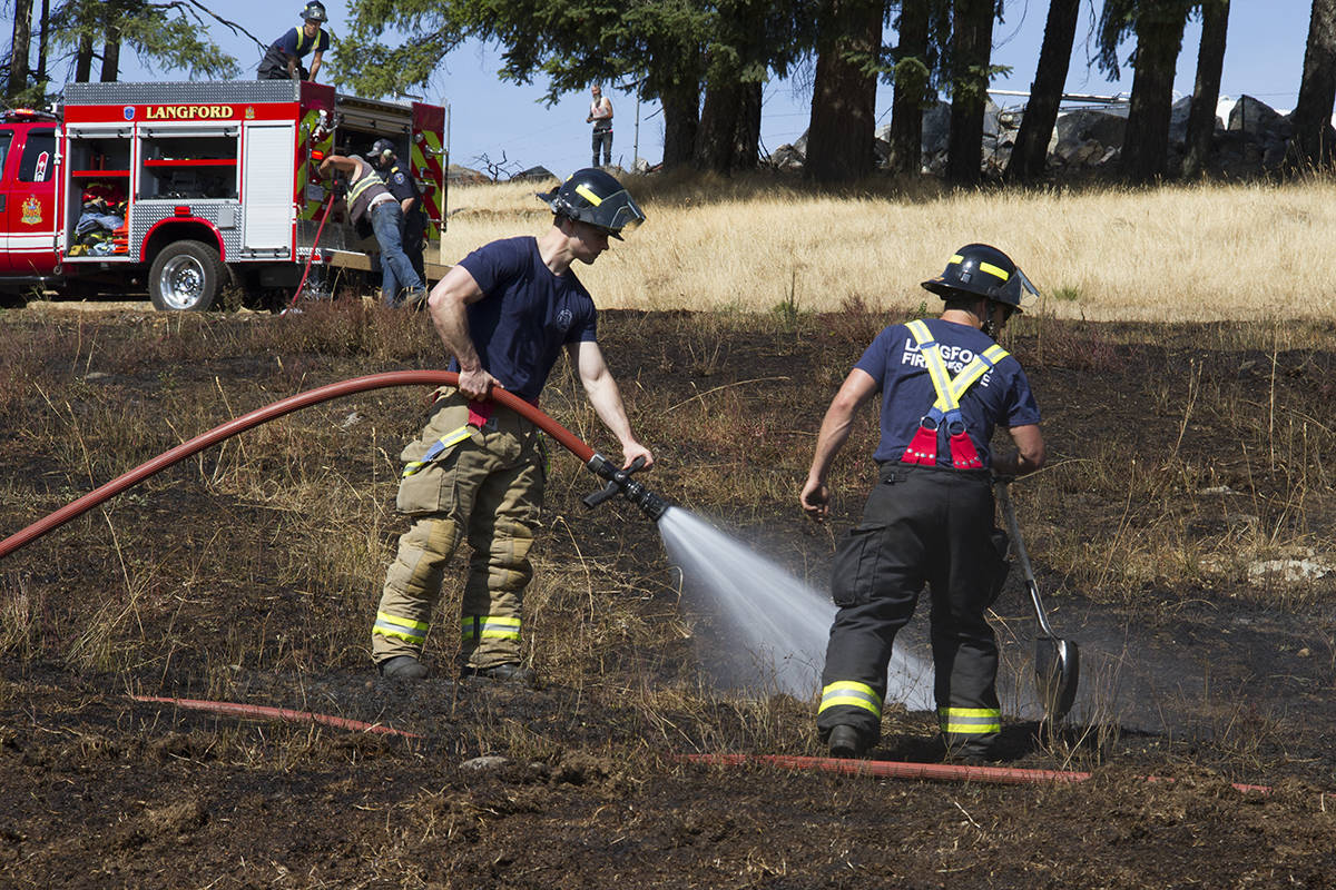 Members of Langford Fire Rescue check for hot spots after a grass fire off of Latoria Road in 2018. Brush fires are a growing concern as more dry weather is predicted for the near future. (Black Press Media file photo)