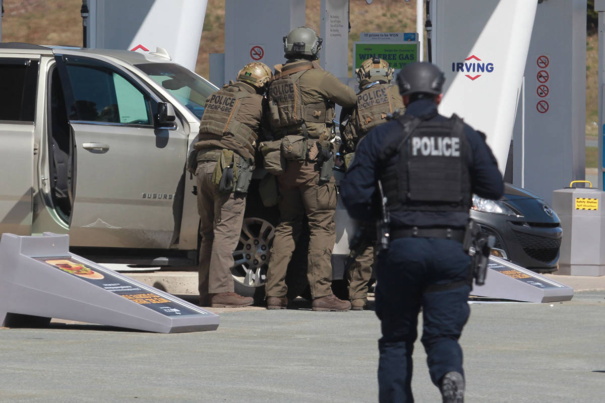 RCMP officers prepare to take a person into custody at a gas station in Enfield, N.S. on Sunday April 19, 2020. THE CANADIAN PRESS/Tim Krochak