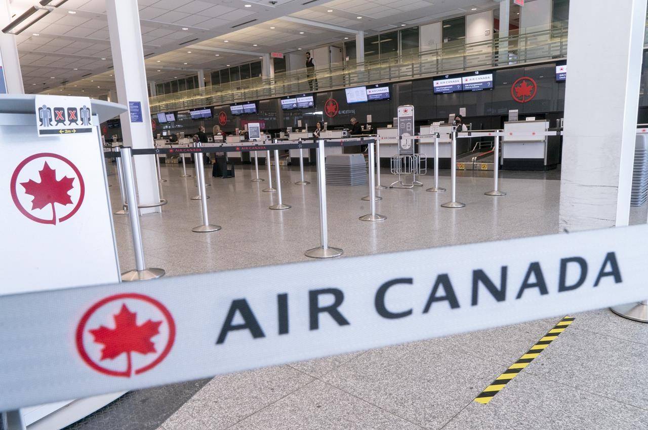An empty Air Canada check-in counter is seen at Montreal-Trudeau International Airport in Montreal, on Wednesday, April 8, 2020. THE CANADIAN PRESS/Paul Chiasson