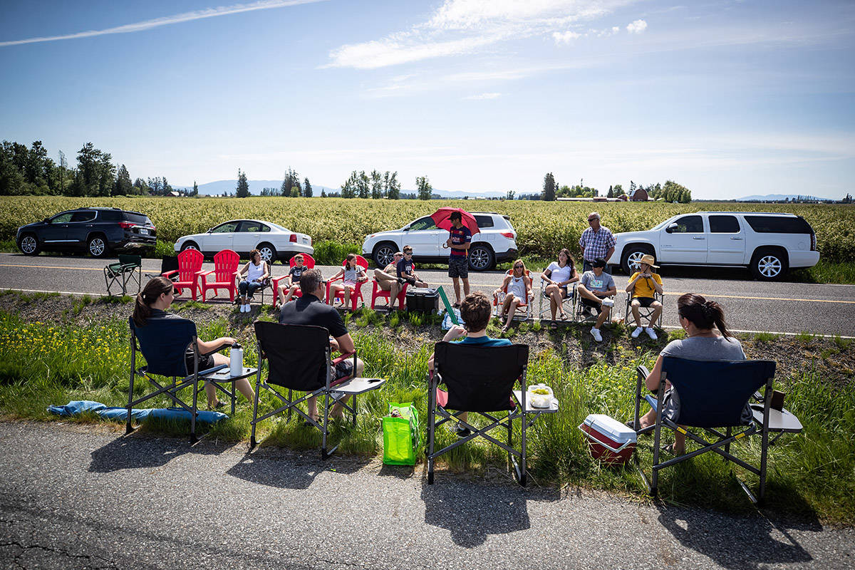 Three generations of the Nunnikhoven family including those who live in Lynden, Wash., back, and those who live in Aldergrove, B.C., front, spend Mother’s Day together separated by a ditch along the Canada-U.S. border, in Aldergrove, B.C., on Sunday, May 10, 2020. The stretch of international border approximately an hour southeast of Vancouver has become a popular meeting spot for families and loved ones separated due to the closure of the Canada-U.S. border to non-essential travel due to COVID-19. THE CANADIAN PRESS/Darryl Dyck
