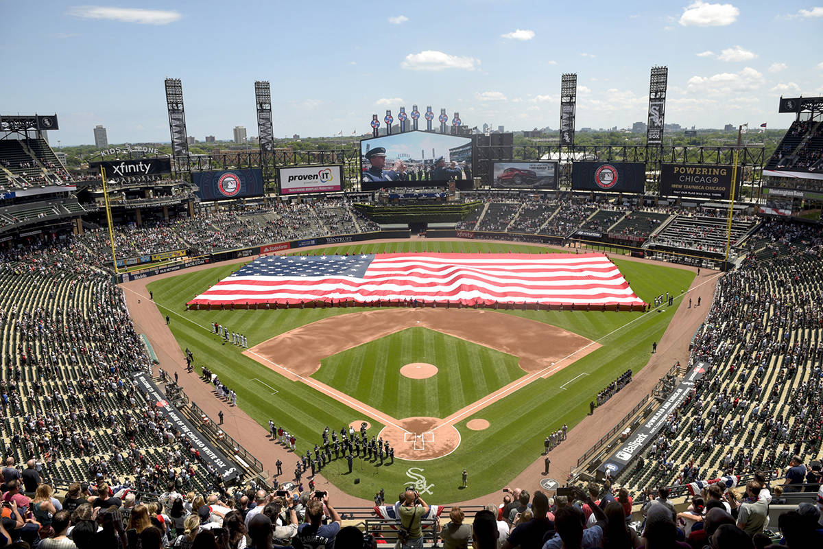 FILE - In this July 4, 2019, file photo, an American Flag is unfurled in the outfield during the playing of the National Anthem before the start a baseball game between the Chicago White Sox and the Detroit Tigers in Chicago. Major League Baseball owners gave the go-ahead Monday, May 11, 2020, to making a proposal to the players’ union that could lead to the coronavirus-delayed season starting around the Fourth of July weekend in ballparks without fans, a plan that envisioned expanding the designated hitter to the National League for 2020. (AP Photo/Mark Black, File)