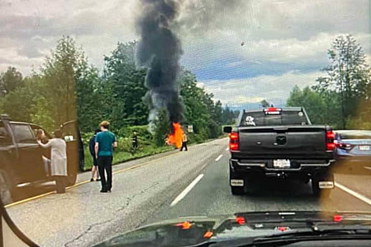 Will Vader, seen on the left wearing the green shirt, pulled the woman and her baby from the car minutes before it burst into flames. Facebook photo.