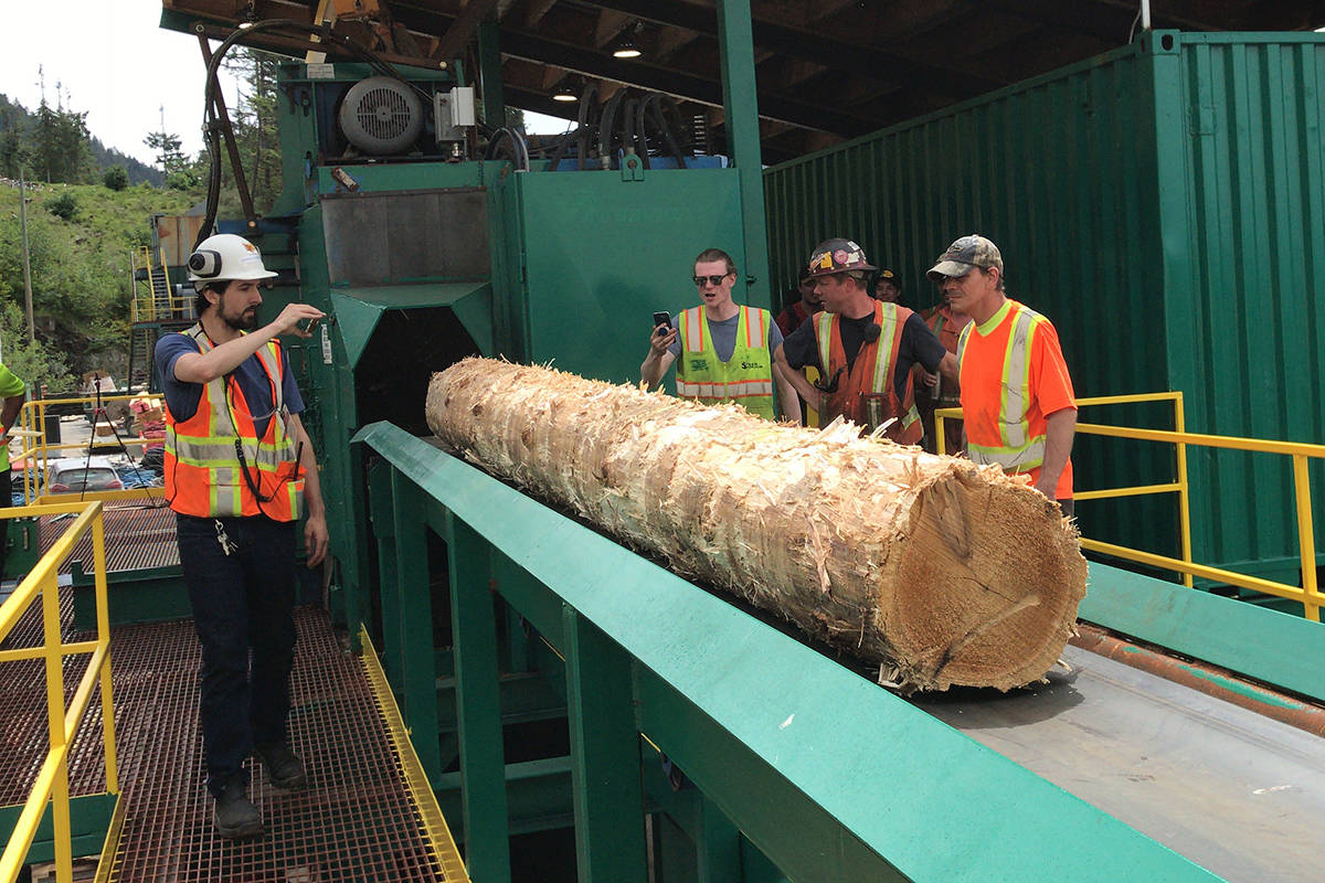 San Group employees and contractors watch the first official log come out of a ring debarker before heading via conveyor to the hewsaw at the new B Mill on San’s Coulson site, Friday, May 29, 2020. (SUSAN QUINN/ Alberni Valley News)