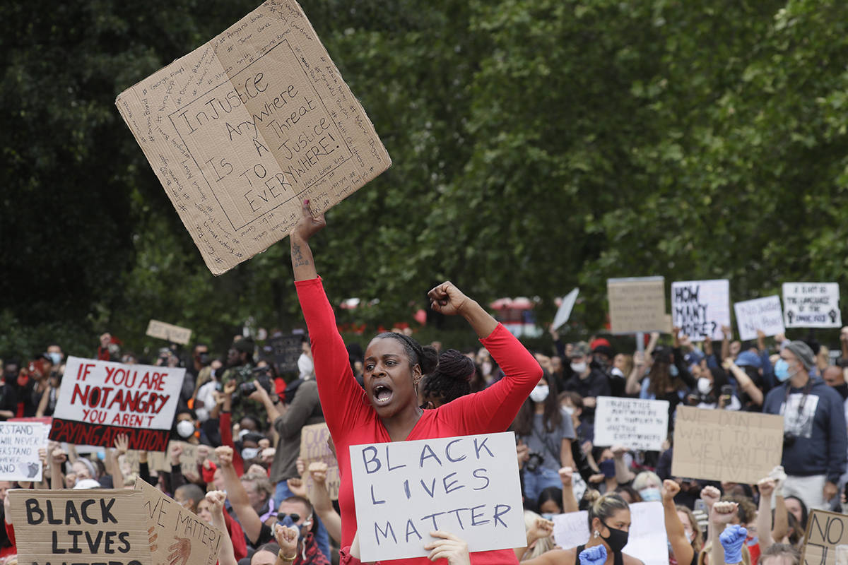 Protesters hold up placards as people gather for a demonstration on Wednesday, June 3, 2020, in Hyde Park, London, over the death of George Floyd, a black man who died after being restrained by Minneapolis police officers on May 25. Protests have taken place across America and internationally, after a white Minneapolis police officer pressed his knee against Floyd’s neck while the handcuffed black man called out that he couldn’t breathe. The officer, Derek Chauvin, has been fired and charged with murder. (AP Photo/Kirsty Wigglesworth)