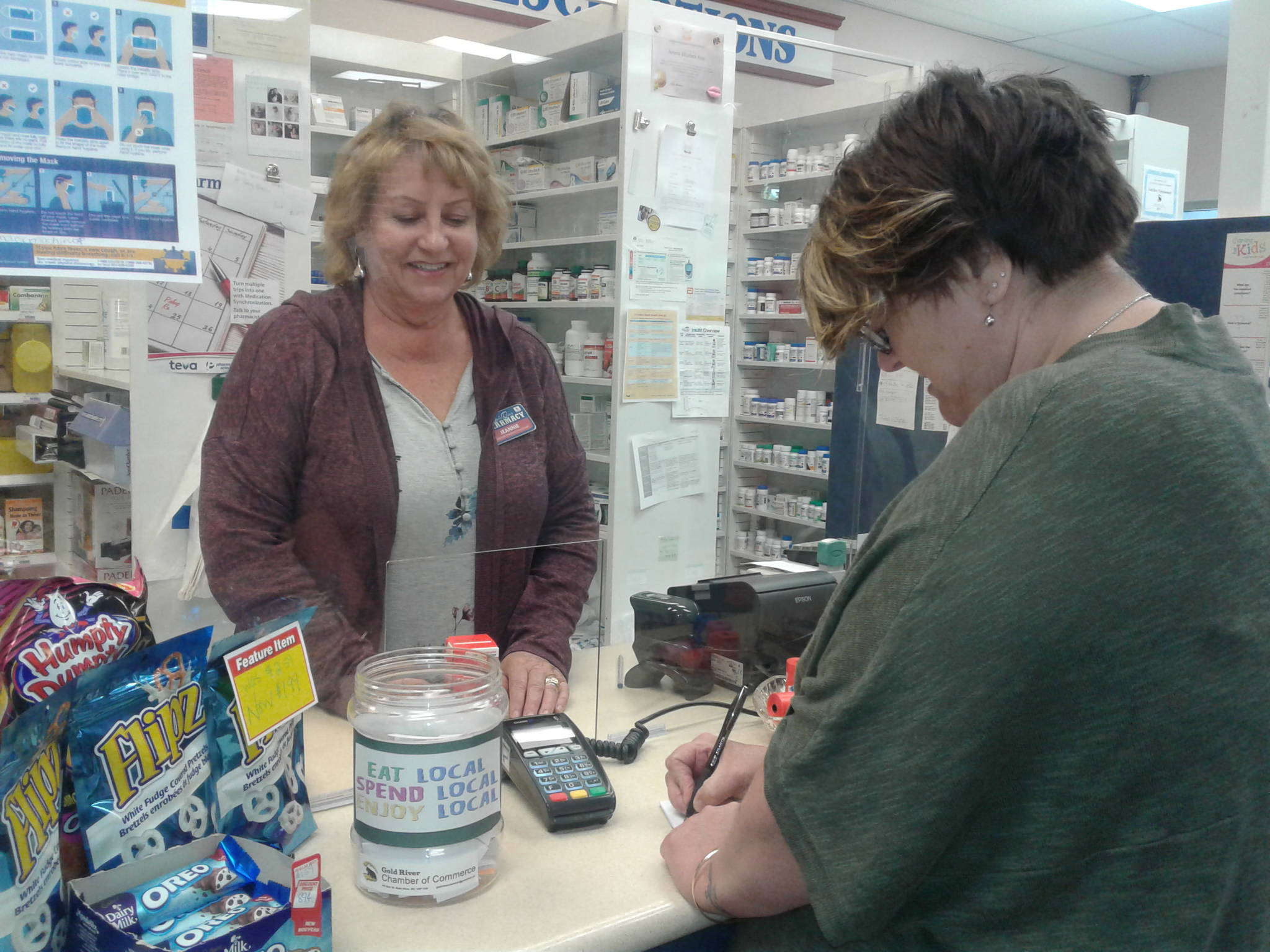 A Gold River resident fills out her details, after shopping at the pharmacy, to qualify for the shop local gift certificate. (Submitted photo)