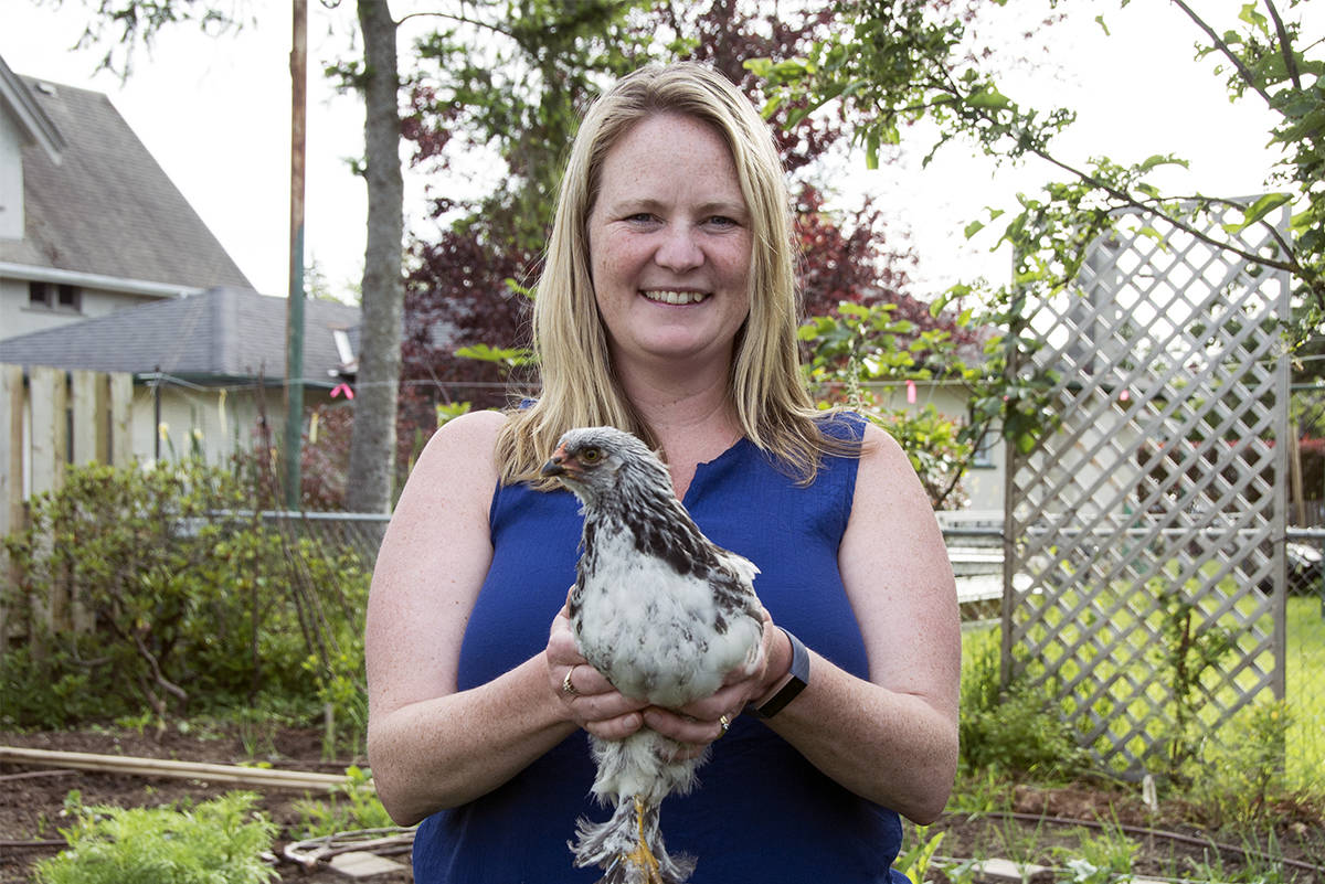 Michelle Kirby holds her Light Brahma chicken, Sakura. The feather-footed hen is only a few months old and is part of the small brood Kirby purchased after the beginning of the COVID-19 pandemic. (Nina Grossman/News Staff)