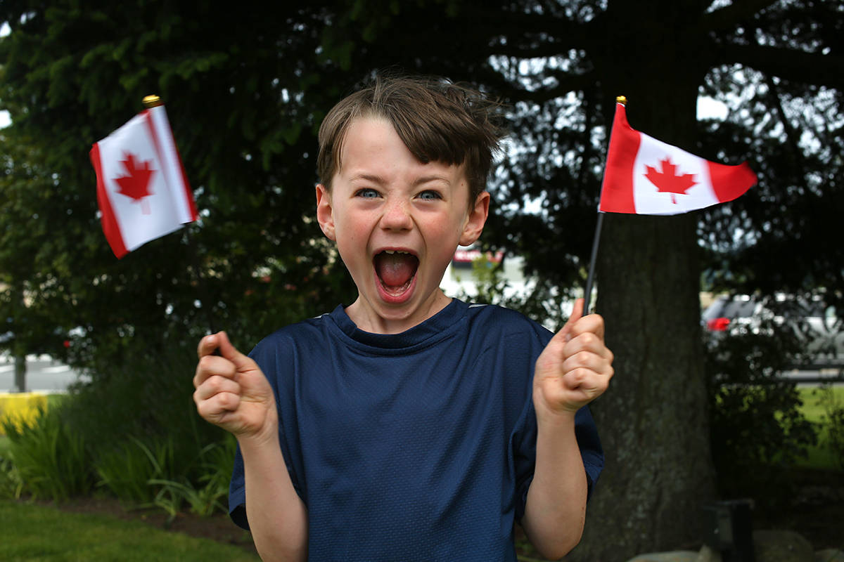 Greater Victoria resident Arthur Barnes waves flags in celebration of Canada Day. (Dawn Gibson/News Staff)