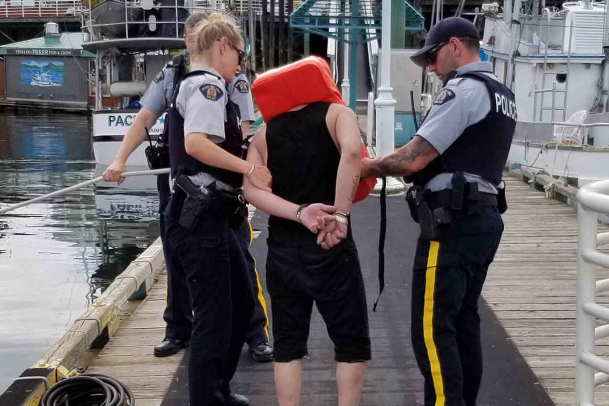 Nanaimo RCMP take a man into custody who allegedly fled after lighting a meth pipe while being questioned by officers. (Photo submitted)