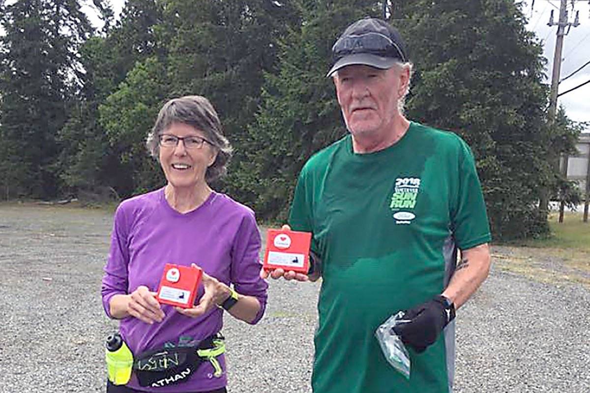Oceanside Running Club Association members Mary Beil and Paul Watson completed the Virtual Half Marathon challenge and receive the award created by organizer Penny Youngash. (ORCA photo)
