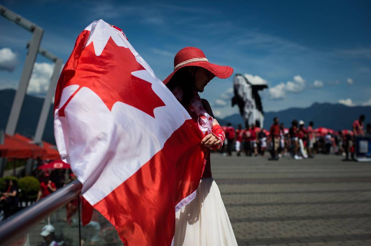 Summer Shen waves a Canadian flag while sporting a patriotic outfit during Canada Day celebrations in Vancouver, on July 1, 2019. The true north remains just as strong but might not feel quite as free with Canada Day celebrations being a little quieter and physically distant as people keep their guard up against COVID-19. From coast to coast to coast the usual festivities, parades and fireworks that accompany Canada Day have been cancelled in many communities this year because of COVID-19, but Canadians are still finding ways to mark the country’s birthday. THE CANADIAN PRESS/Darryl Dyck