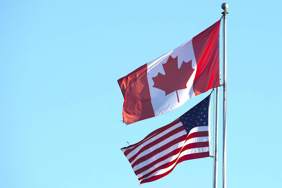 The Canadian and American flags are seen on top of the Peace Arch is at the Canada/USA border in Surrey, B.C. Friday, March 20, 2020. A new online poll suggests COVID-19 has damaged the trust Canadians have in their American neighbours, while U.S. residents have more faith in their northern counterparts than they do in themselves. THE CANADIAN PRESS/Jonathan Hayward
