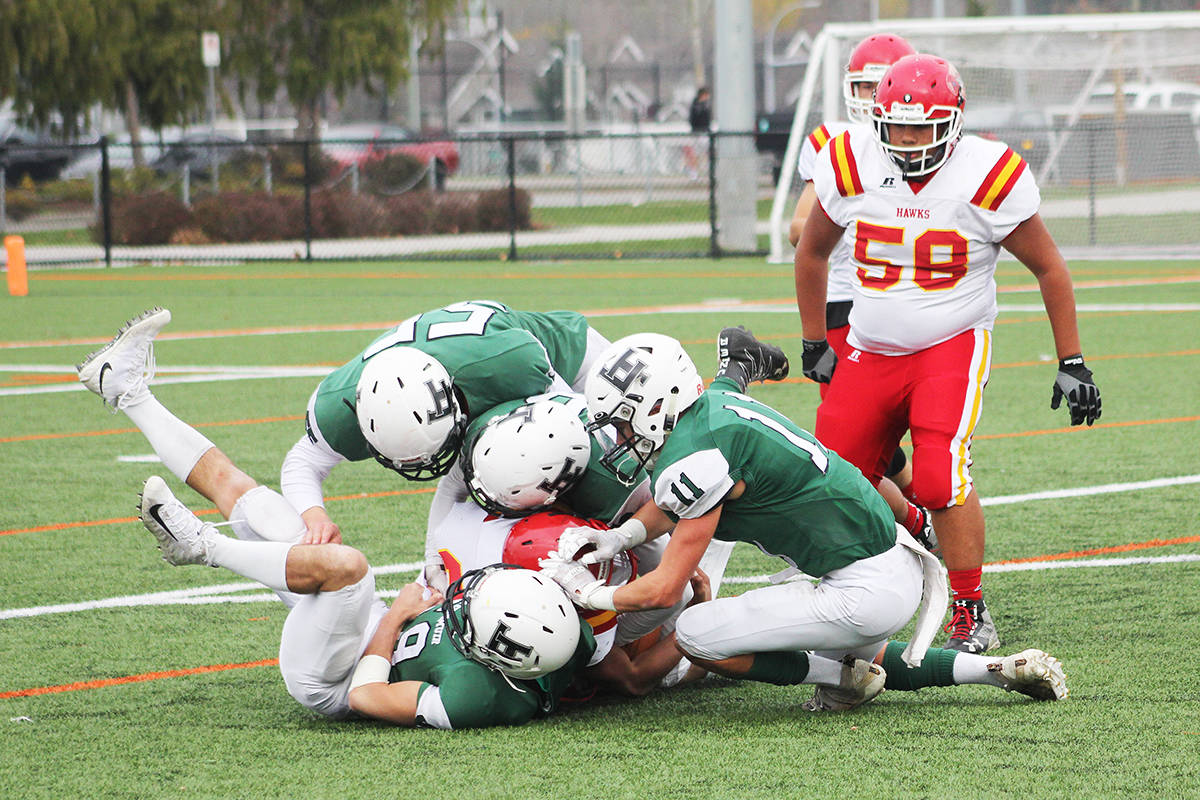 Lord Tweedsmuir football players swarm a lone W.J. Mouat Hawk Nov. 8, 2019 at Cloverdale Athletic Park. High school athletes still don’t know whether they will be playing sports this fall or not. (Photo: Malin Jordan)