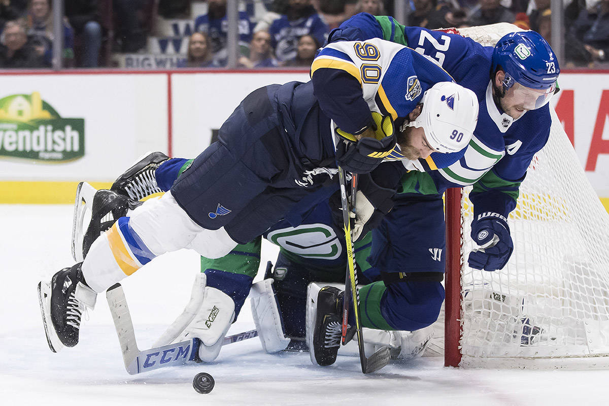 Vancouver Canucks’ Alexander Edler (23), of Sweden, hauls down St. Louis Blues’ Ryan O’Reilly (90) in front of goalie Jacob Markstrom, back, of Sweden, during the third period of an NHL hockey game in Vancouver, on Tuesday November 5, 2019. The Canucks meet the Minnesota Wild in 2020 ‘play-in’ series action. THE CANADIAN PRESS/Darryl Dyck