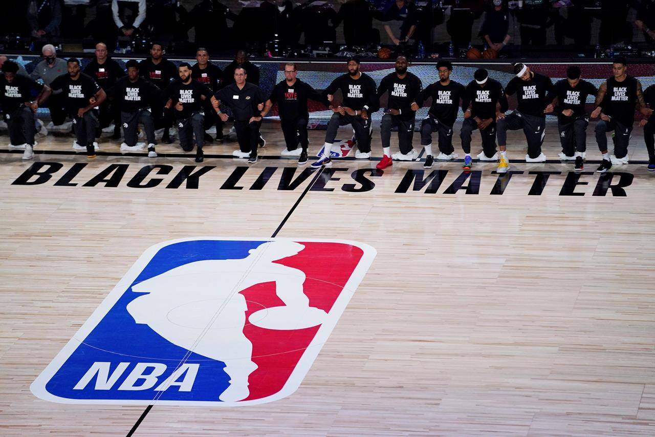 Players kneel before an NBA basketball game between the Los Angeles Lakers and the Toronto Raptors, Saturday, Aug. 1, 2020, in Lake Buena Vista, Fla. (AP Photo/Ashley Landis, Pool)
