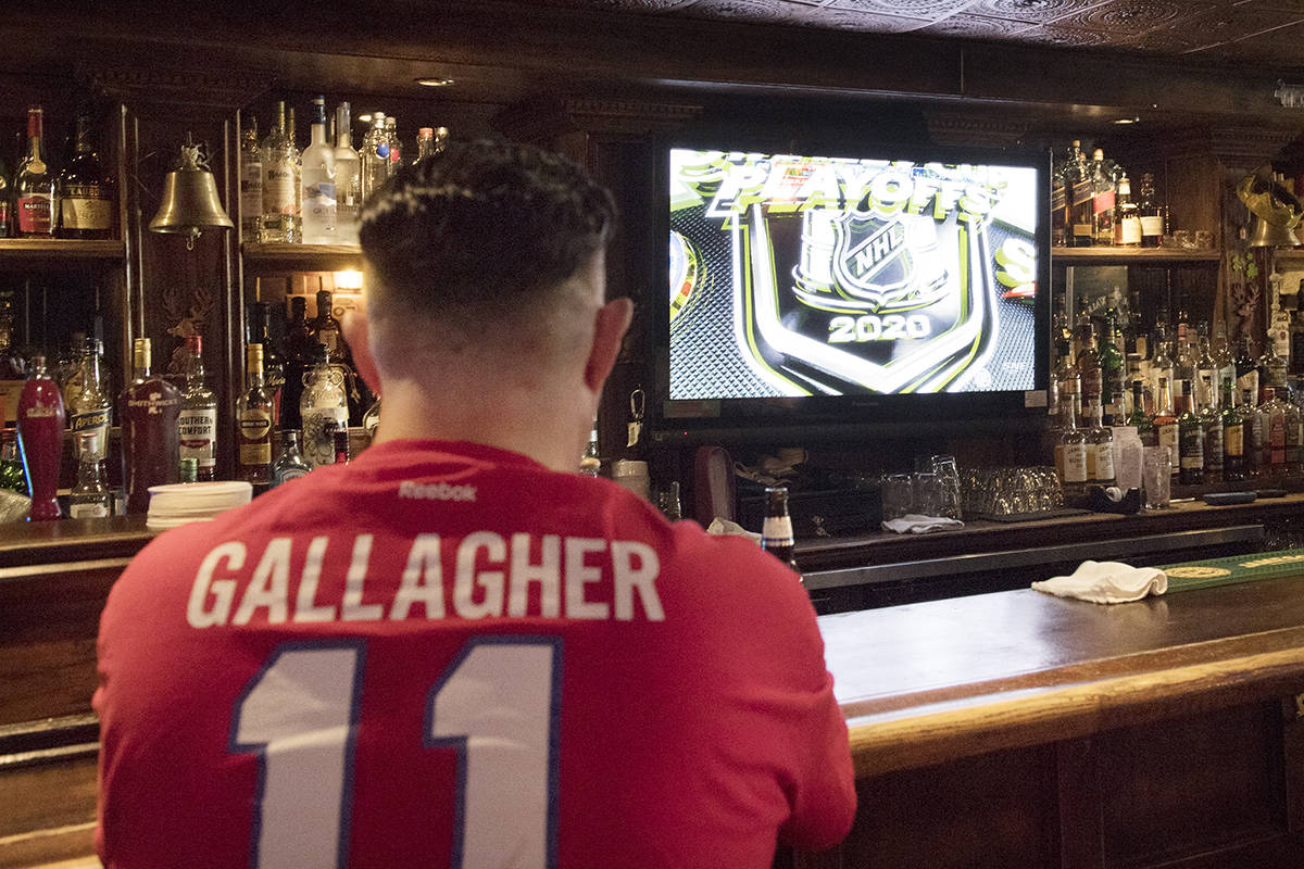 A man watches the NHL Stanley Cup playoffs at a bar in Montreal, Saturday, Aug. 1, 2020. THE CANADIAN PRESS/Graham Hughes