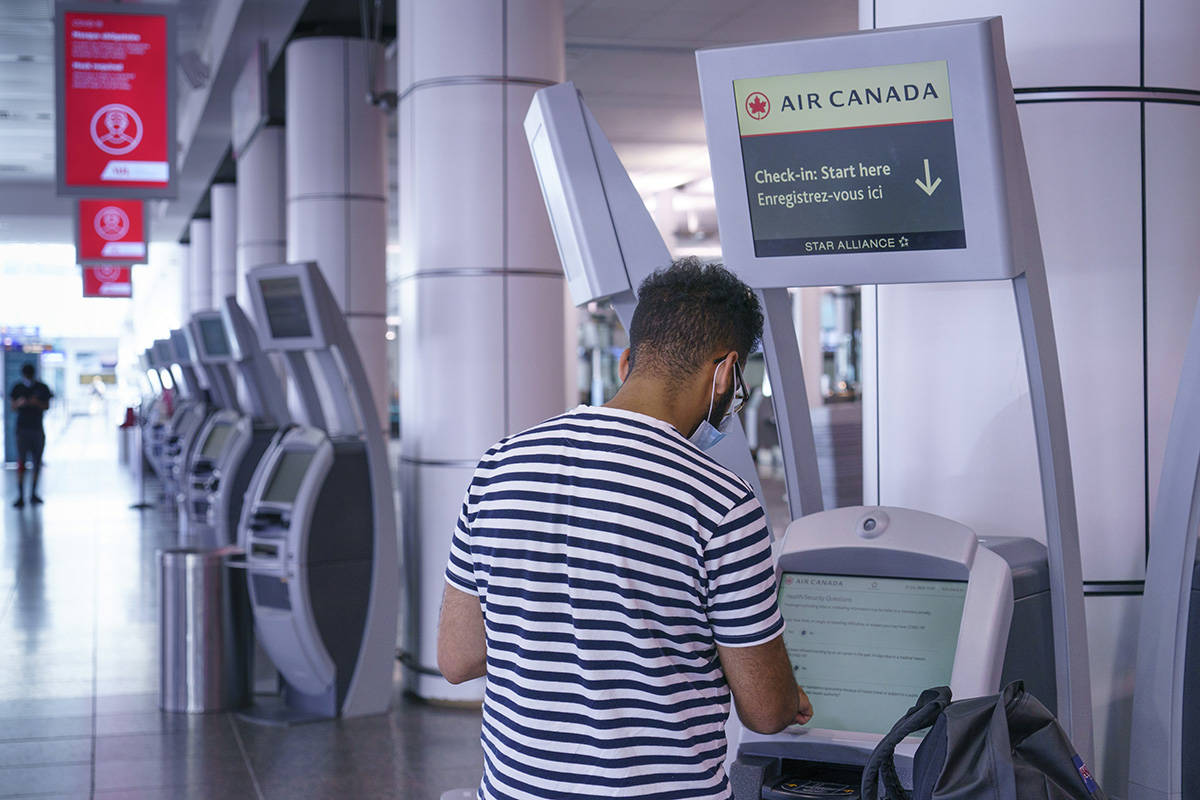 A passenger uses an Air Canada self service check-in kiosk at Montreal-Trudeau International Airport in Montreal, on Friday, July 31, 2020. THE CANADIAN PRESS/Paul Chiasson