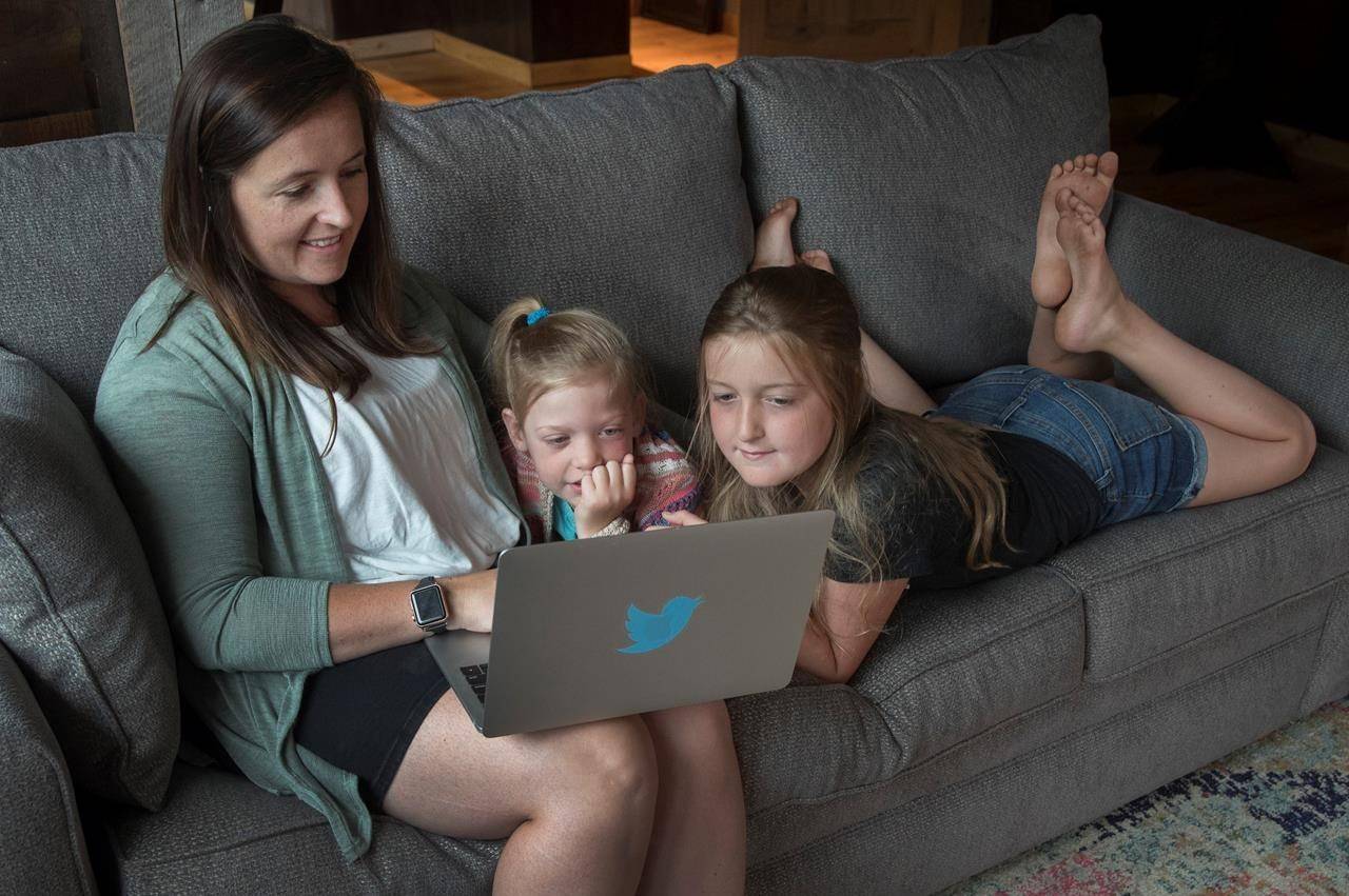 Andrea MacDonald with her daughters Rose, 5, and Grace, 9, take part online with Twitter’s “virtual camp” at their summer residence in Harcourt, Ont., Sunday, August 2, 2020. When MacDonald begins working from home each morning, keeping her two daughters busy is rarely a worry. Grace and Rose have spent the last two months being read Dr. Seuss books by Twitter Inc. founder Jack Dorsey and learning about literary terms through Harry Potter. Both are part of Camp Twitter, a virtual program for kids of the tech company’s employees. The offering is one of several dreamed up by companies to help Canadian employees juggle their professional and parenting duties, while working from home and having limited camps, daycare, school or child care options to lean on during the COVID-19 pandemic. THE CANADIAN PRESS/Fred Thornhill