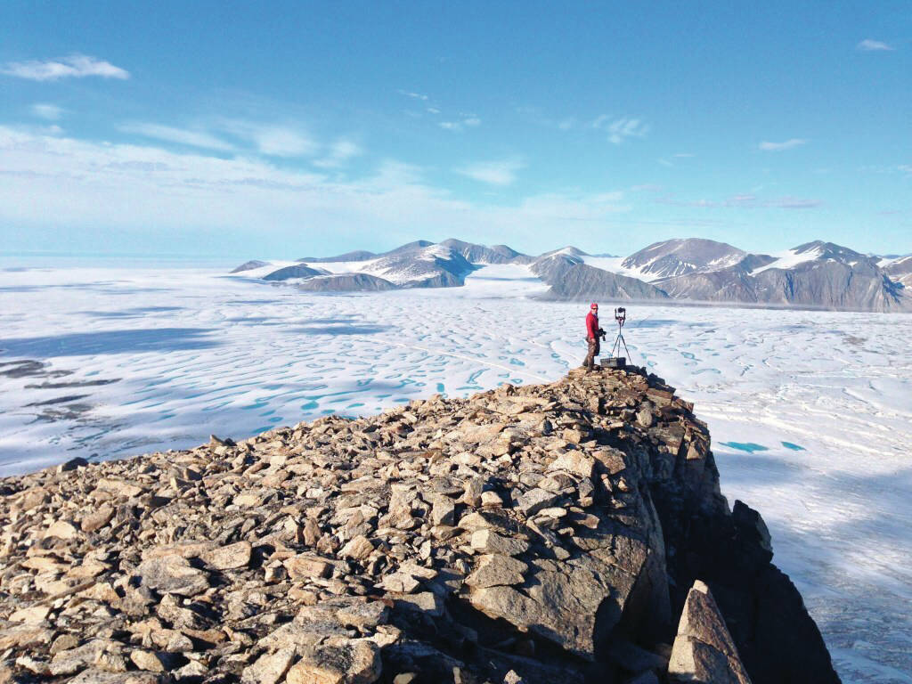 This July 2015 photo taken by University of Ottawa glaciology professor Luke Copland shows Canadian Ice Service ice analyst Adrienne White taking a photo of cracks of the Milne Ice Shelf, which just broke apart. The Milne ice shelf was on of the Arctic’s few remaining intact ice shelves, but at the end of July 2020 about 43% broke off. Scientists say that without a doubt it’s man-made global warming. (Luke Copland via AP)