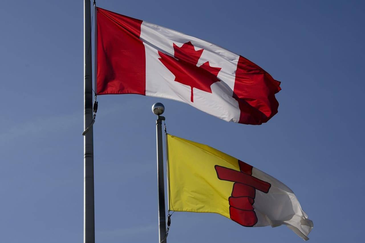 A Canada flag flies beside an Nunavut flag in Iqaluit, Nunavut on July 31, 2019. The government of Nunavut is affirming its intention to create a civilian police oversight body after a recent review of a shooting death of an Inuit man. Territorial Justice Minister Jeannie Ehaloak says it’s a priority for her government to stop relying on other police forces to investigate actions of the RCMP. THE CANADIAN PRESS/Sean Kilpatrick