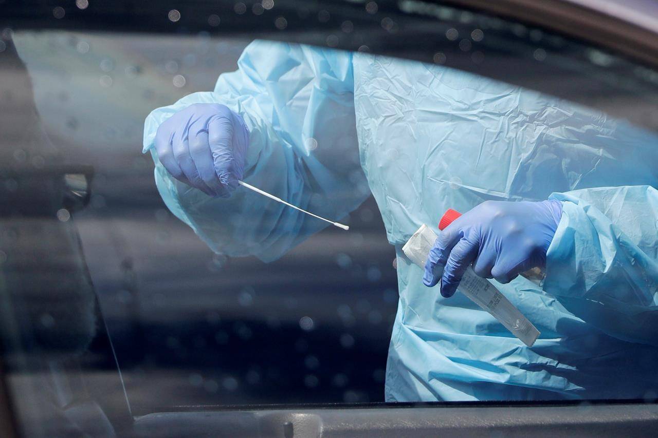 A medical assistant prepares to take a swab from a patient at a drive-through and walk-up coronavirus testing site in Seattle, Saturday, April 25, 2020. THE CANADIAN PRESS/AP-Elaine Thompson