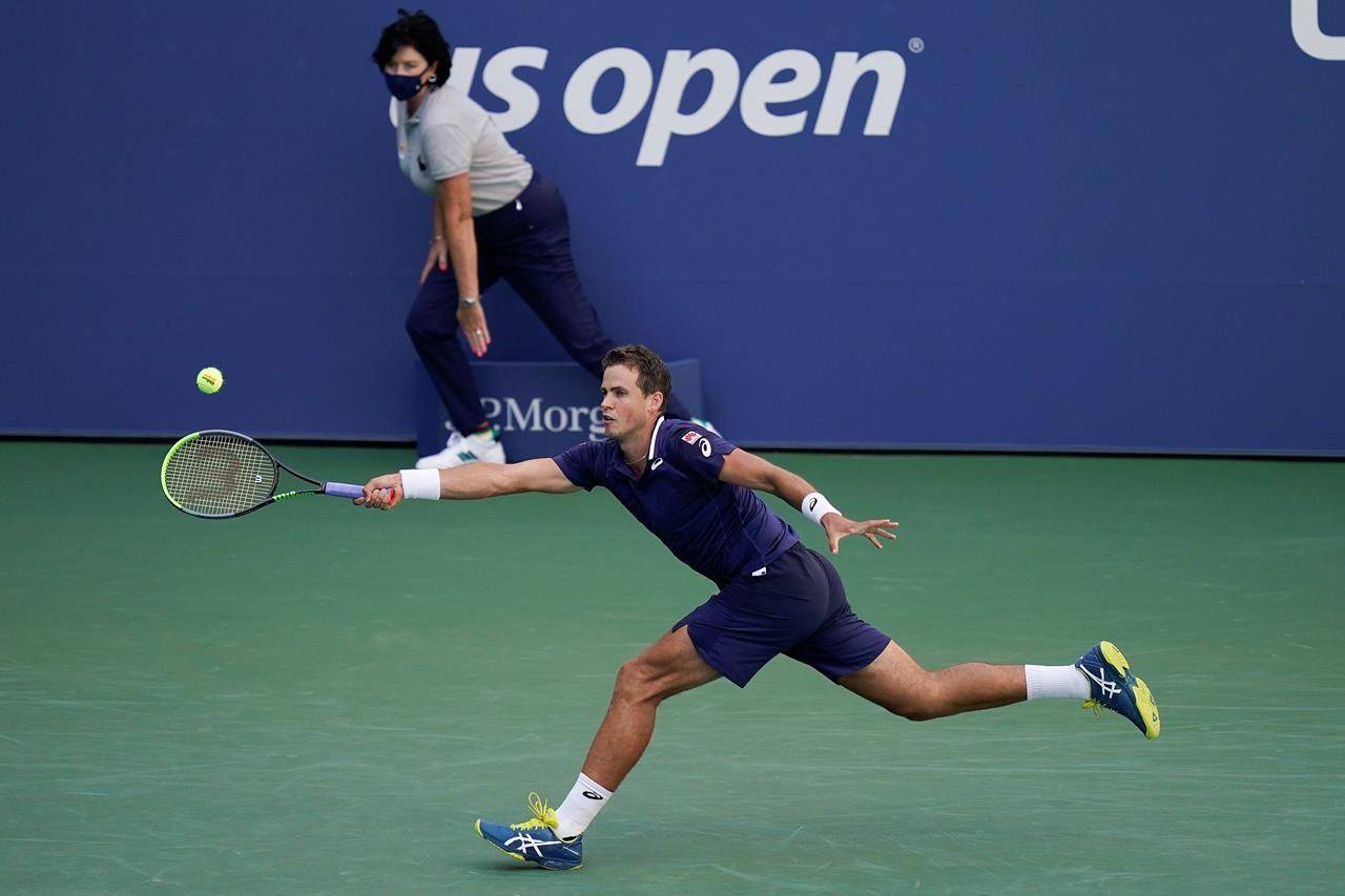 Vernon’s Vasek Pospisil returns a shot to Roberto Bautista Agut, of Spain, during the third round of the US Open tennis championships, Saturday, Sept. 5, 2020, in New York. (AP Photo/Seth Wenig)