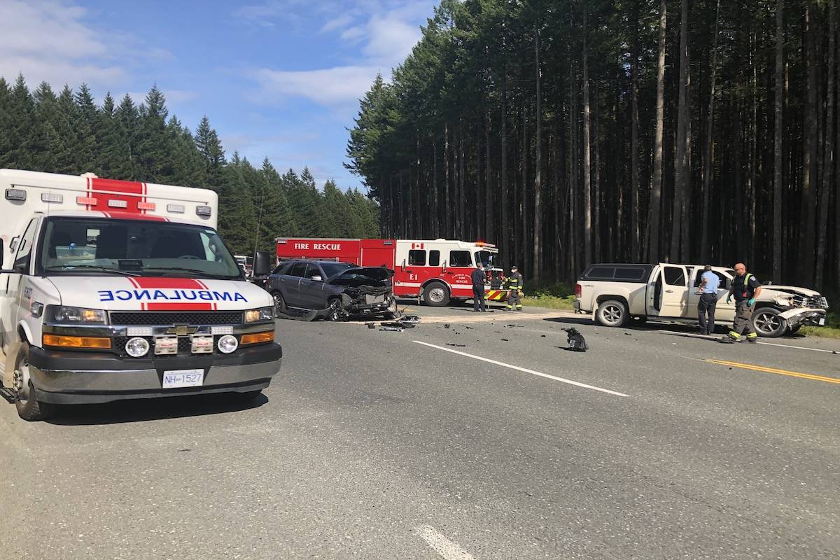 Paramedics and RCMP officers tend at the site of a crash on Highway 28, August 14, 2020. Photo by Binny Paul/Campbell River Mirror