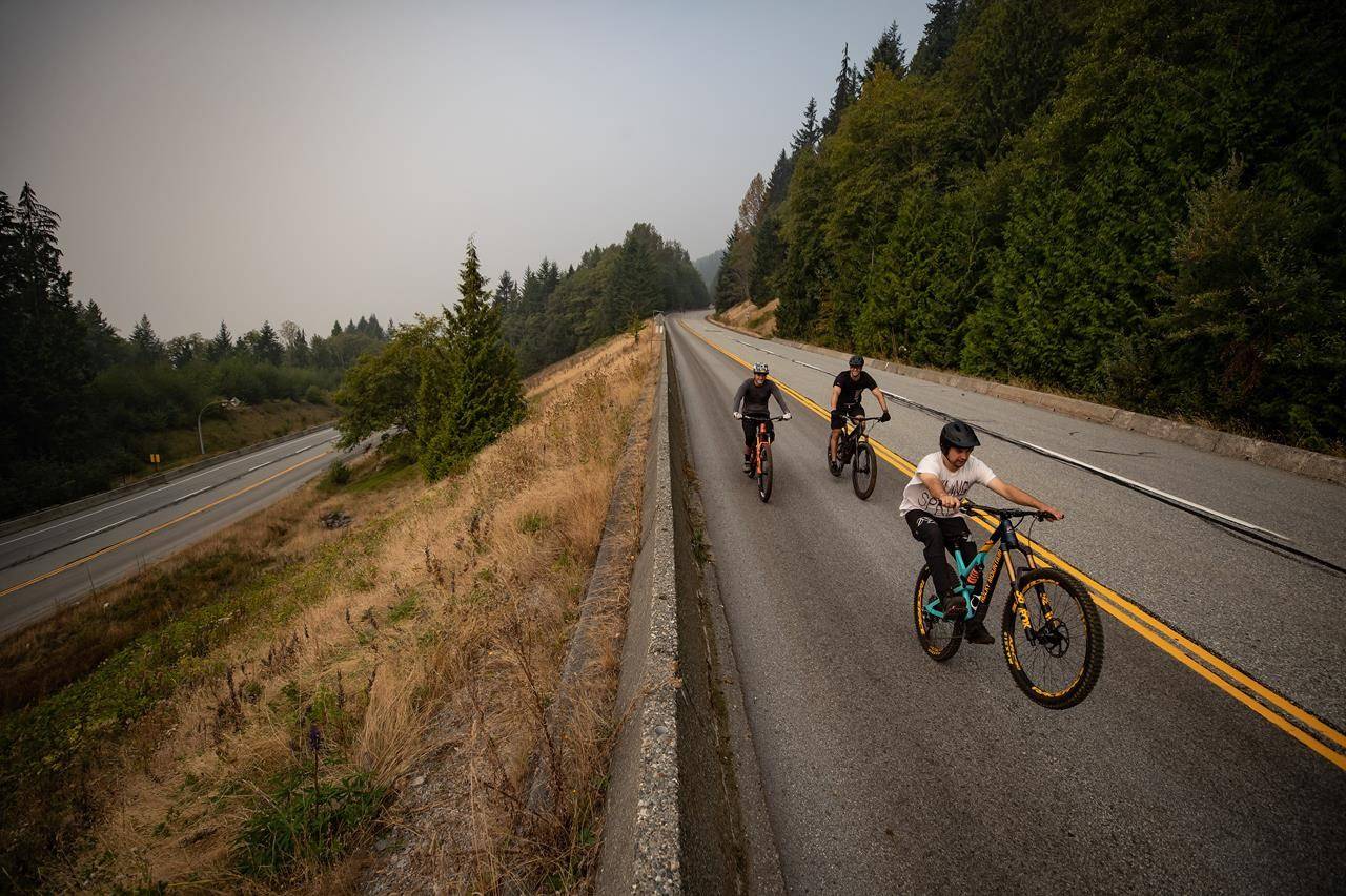 Smoke from wildfires burning in the U.S. fills the air as people ride bikes down the road at Cypress Provincial Park, in West Vancouver, B.C,, on Saturday, September 12, 2020. THE CANADIAN PRESS/Darryl Dyck