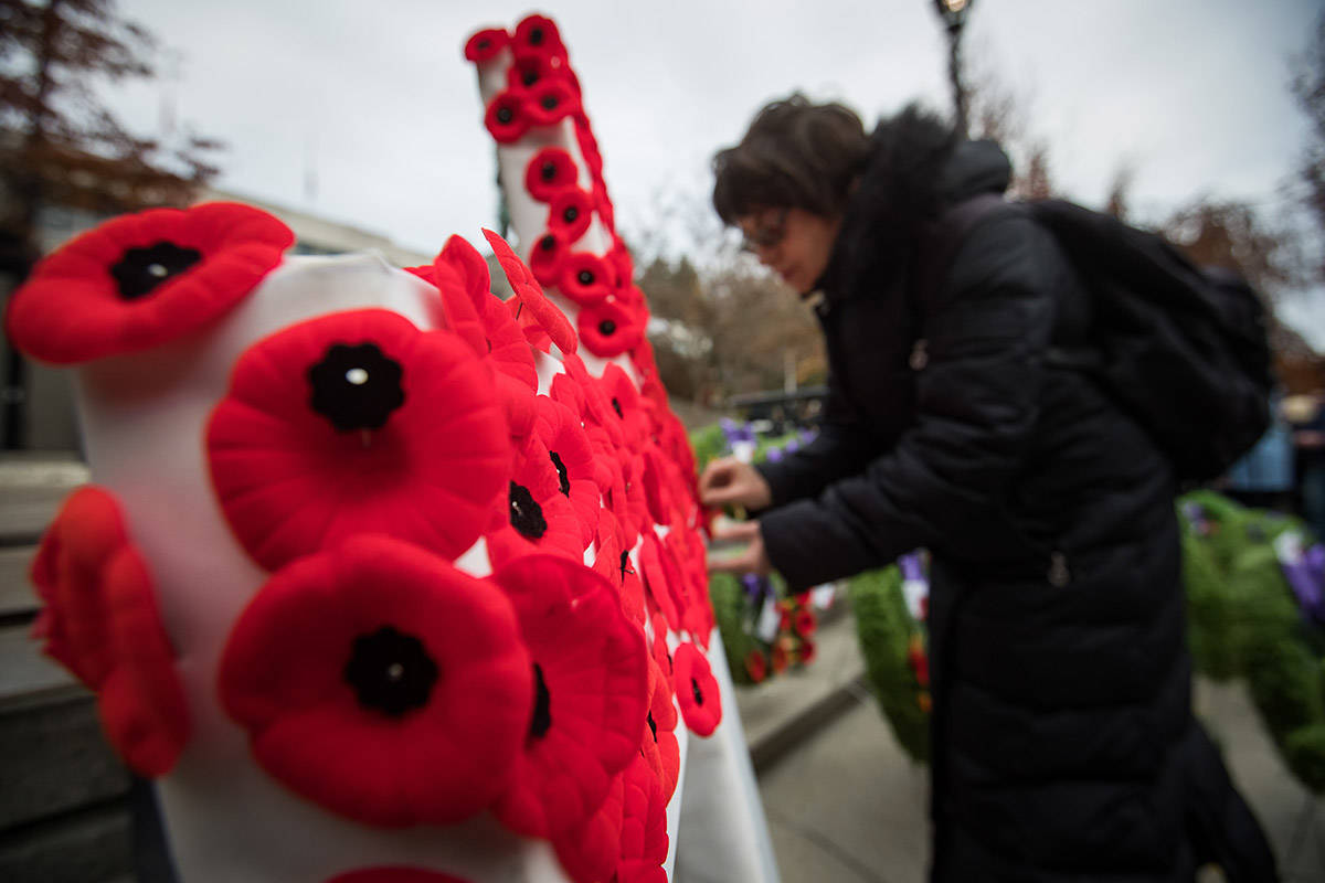 A woman pins her poppy on a cross after a Remembrance Day ceremony at the cenotaph in New Westminster, B.C., on Monday November 11, 2019. THE CANADIAN PRESS/Darryl Dyck