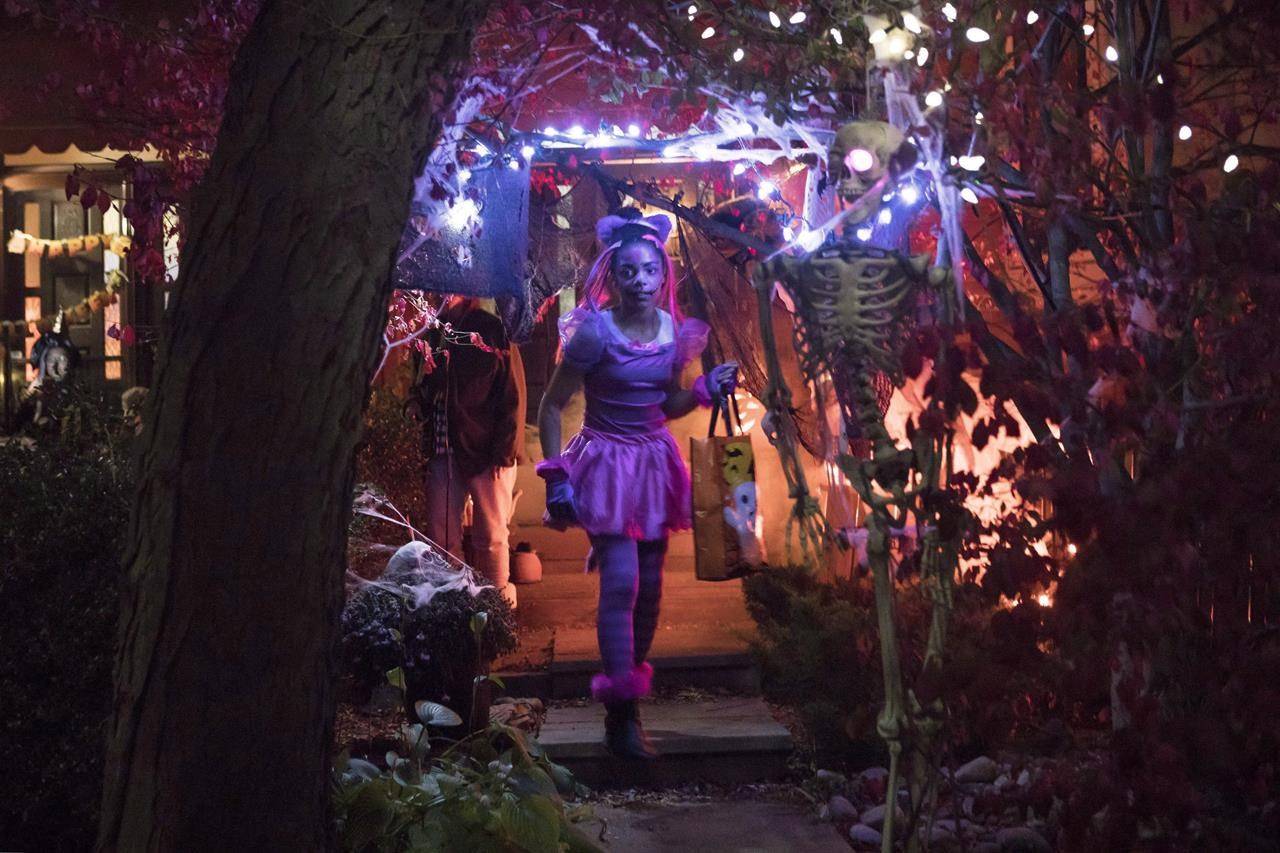 Eleven-year-old Hayley McDermott walks down the pathway of a decorated house during Halloween celebrations in Toronto, Tuesday, Oct. 31, 2017. THE CANADIAN PRESS/Chris Young