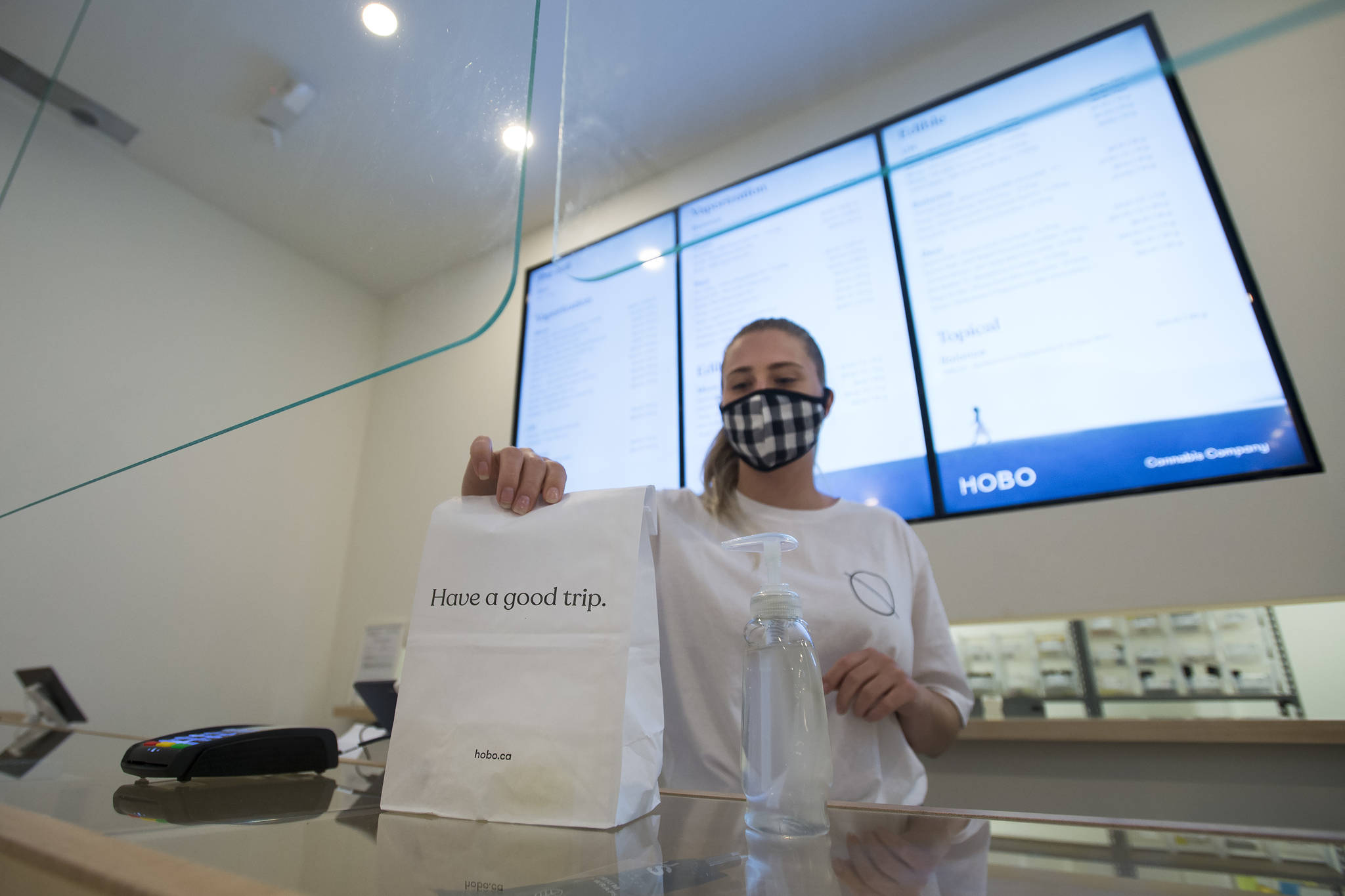 Employee Sophia Lovink shows off a bag of merchandise in Toronto on Thursday, June 11, 2020. (THE CANADIAN PRESS/Nathan Denette)