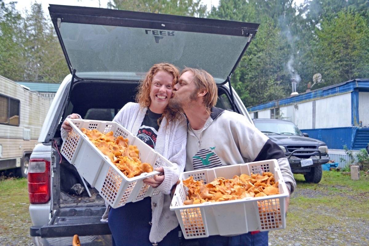 Thaddeus Lenover kisses his mushroom picking partner Teagan Evans on the cheek after a rainy day out in the woods harvesting wild mushrooms. (Nora O'Malley photo)