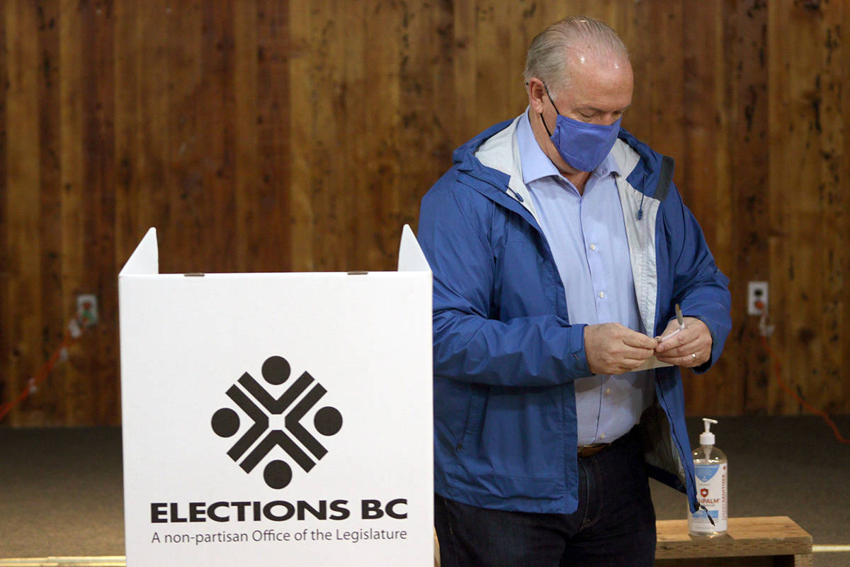 B.C. NDP Leader John Horgan folds his ballot as he votes at Luxton Hall during advance polls for the provincial election in Langford, B.C., Monday, Oct. 19, 2020. THE CANADIAN PRESS/Chad Hipolito