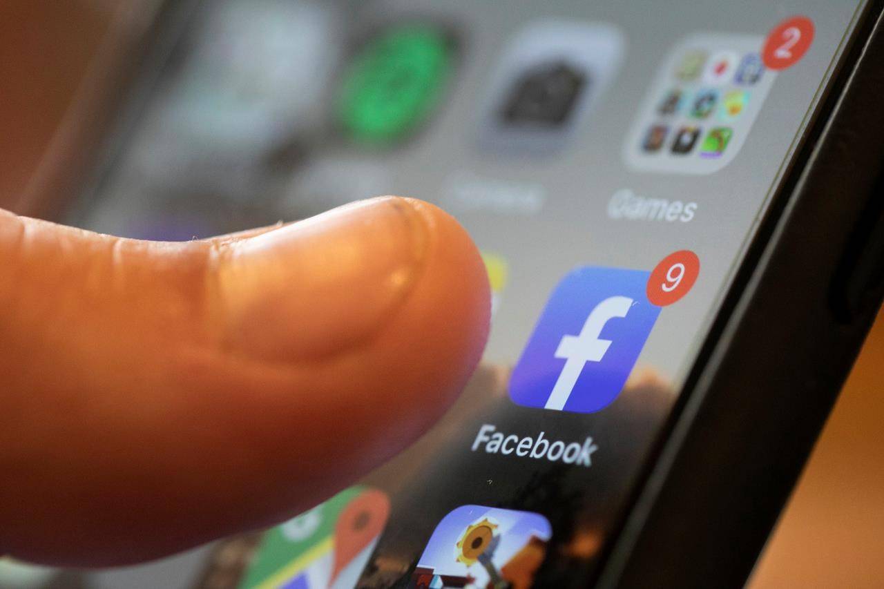 An iPhone displays the Facebook app in New Orleans on Aug. 11, 2019. Two Facebook users are seeking damages on behalf of hundreds of thousands of Canadians whose personal data may have been improperly used for political purposes. THE CANADIAN PRESS/AP, Jenny Kane