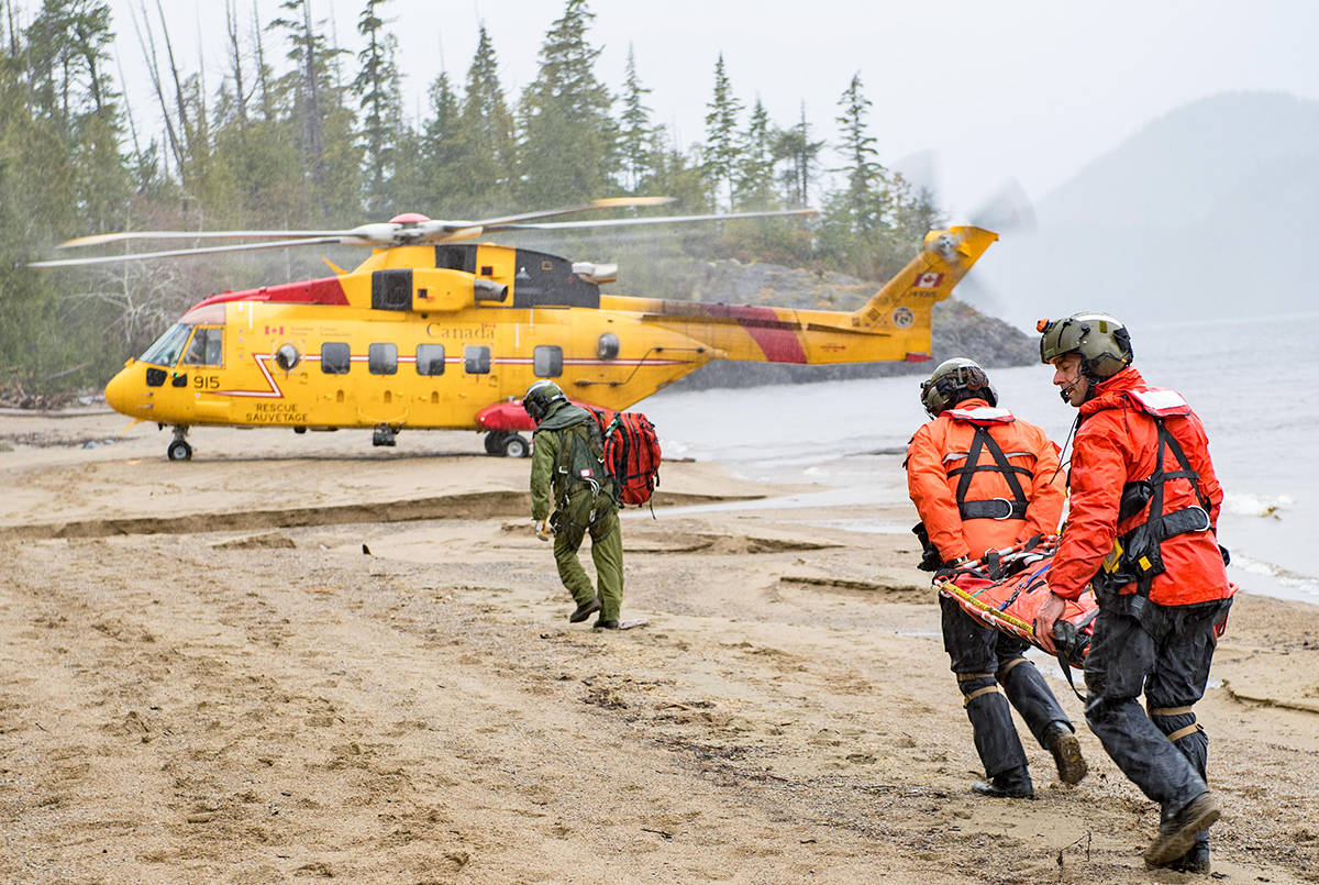 Search and Rescue Technicians carry a stretcher to the CH149 Cormorant during a 442 Squadron Search and Rescue Exercise in Tofino on February 28. (Photo by: Cpl Joey Beaudin, 19 Wing Imaging, Comox)