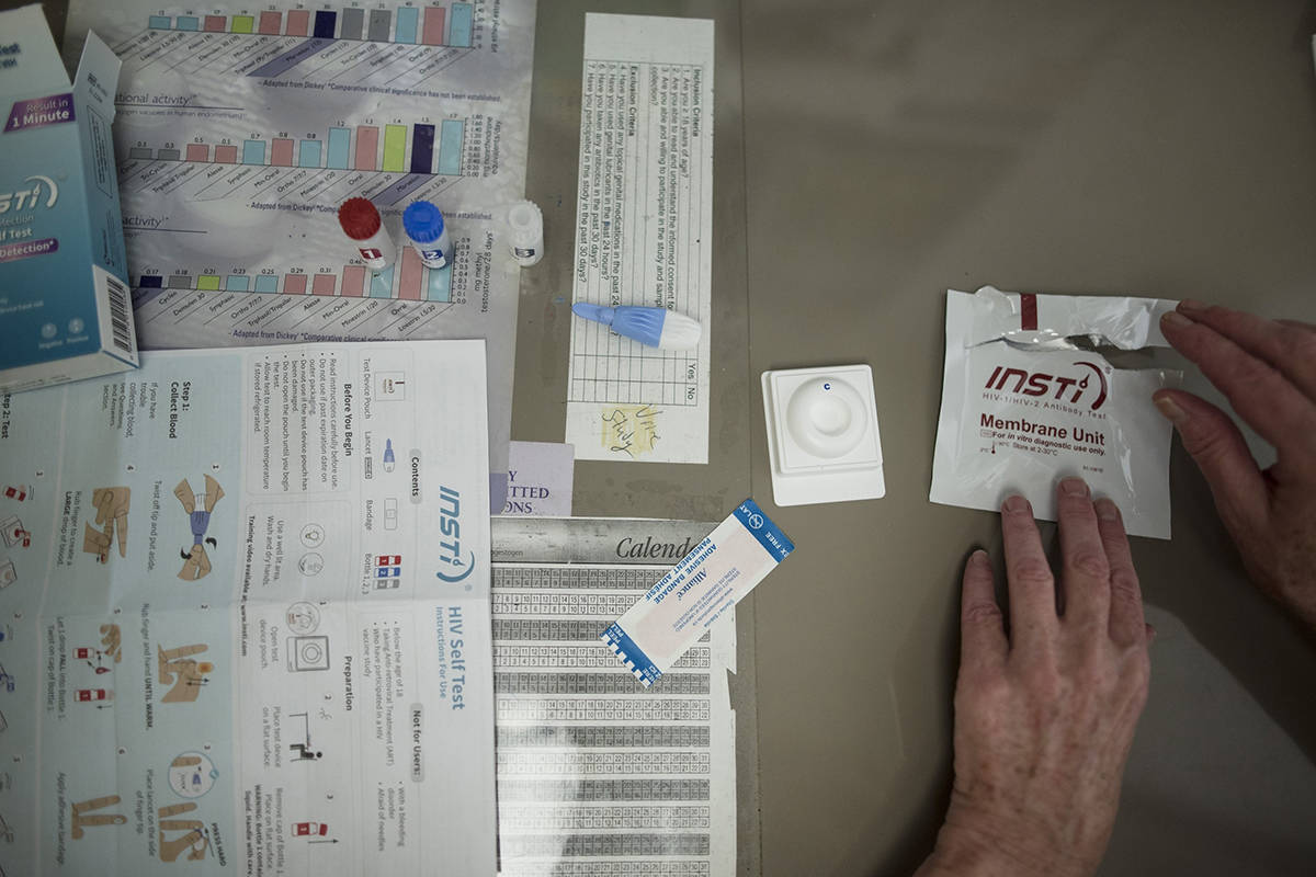 FILE – Jane Greer of the Hassle Free Clinic, unboxes an HIV self-testing kit in Toronto on Wednesday, August 7, 2019. THE CANADIAN PRESS/ Tijana Martin