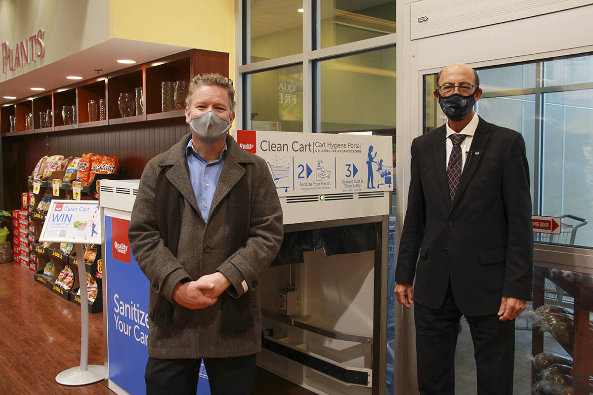 Quality Foods advertising manager, Regan Beaulieu, (left) and president, Noel Hayward, (right) stand in front of the Clean Cart on its first day of testing, Nov. 12. (Jane Skrypnek/News Staff)