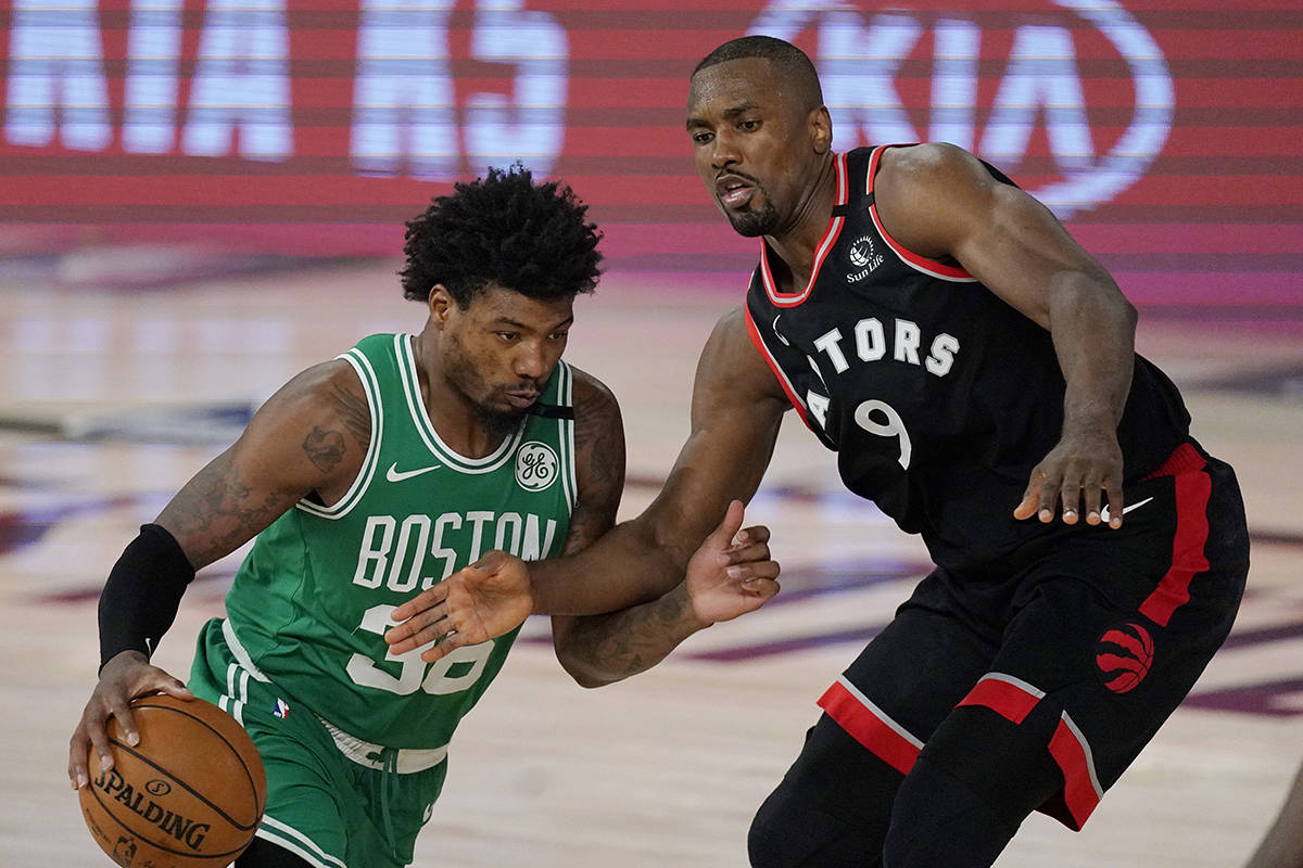 Boston Celtics’ Marcus Smart (36) moves around Toronto Raptors’ Serge Ibaka (9) in the second half of an NBA conference semifinal playoff basketball game Thursday, Sept 3, 2020, in Lake Buena Vista Fla. (AP Photo/Mark J. Terrill)
