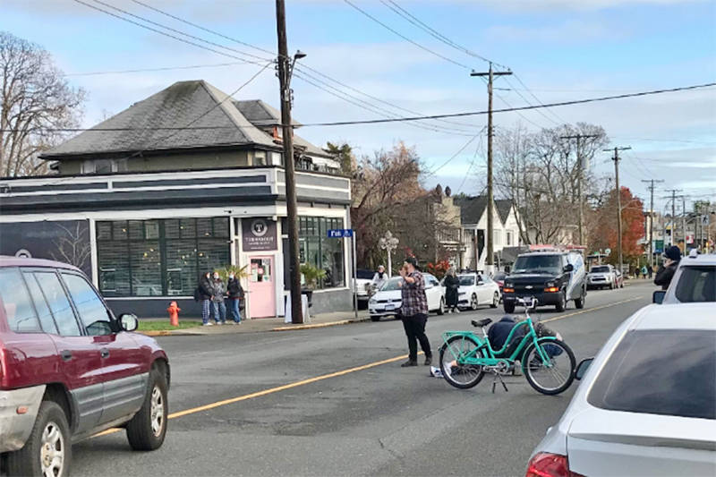 Bystanders attend to a cyclist who is knocked to the pavement of Oak Bay Avenue. Witnesses say the cyclist was knocked off their bike in a dooring incident on Oak Bay Avenue at Fell Street at around 12:40 p.m. on Wednesday. 
(Daniel Opden Dries Photo)