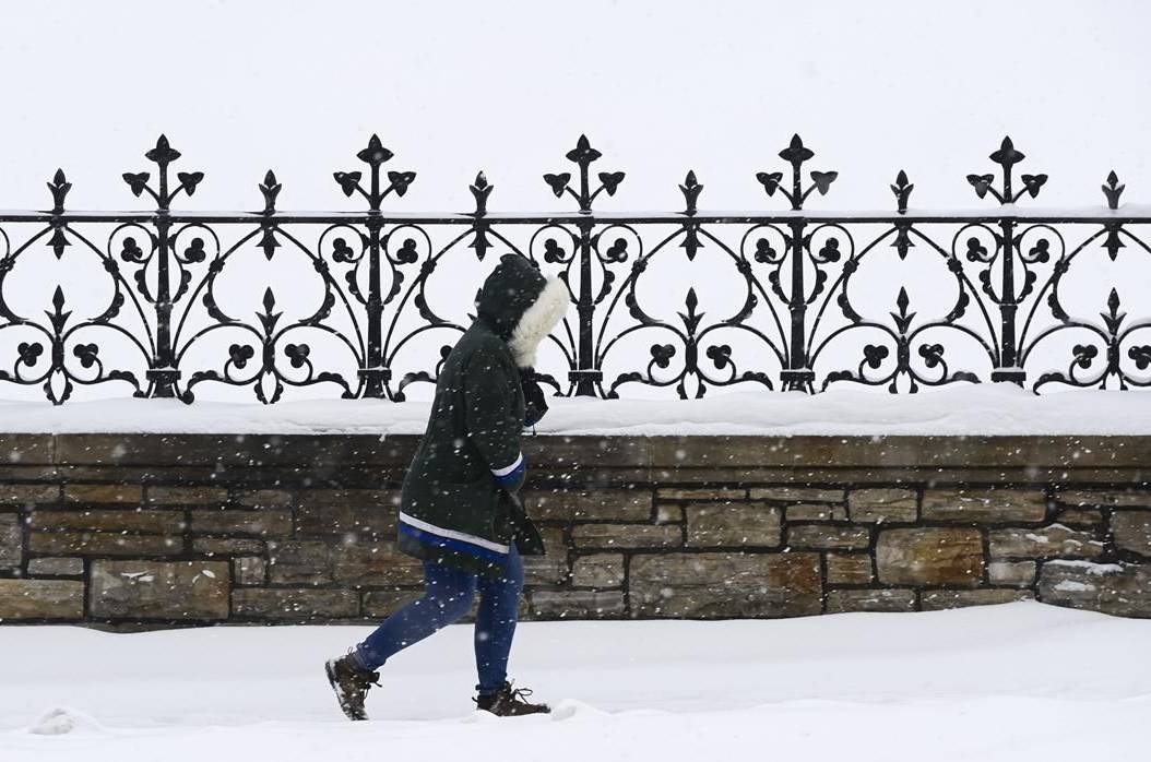 A pedestrian makes their way through the snow in downtown Ottawa on Wednesday, Nov. 25, 2020. THE CANADIAN PRESS/Sean Kilpatrick