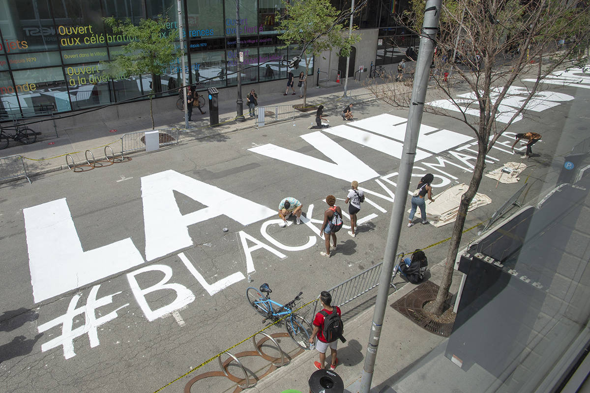 People paint Black Lives Matter if English and French on Ste. Catherine Street Tuesday July 14, 2020  in Montreal.THE CANADIAN PRESS/Ryan Remiorz