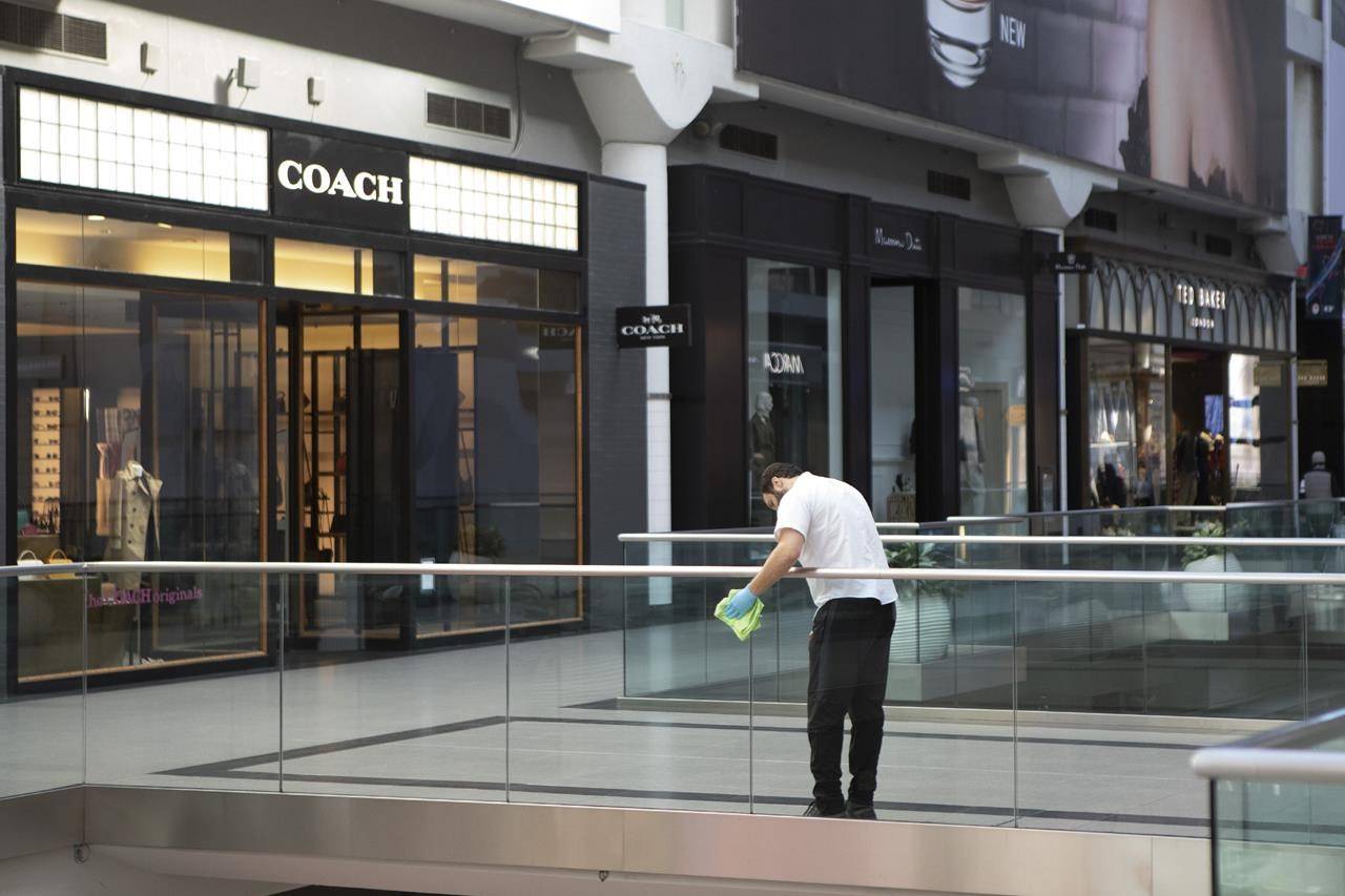 A cleaner wipes a glass panel at Toronto’s Eaton Centre Shopping mall on Saturday, March 21, 2020. The national statistics office will say this morning how much the domestic economy bounced back in the third quarter of the year. The Canadian economy suffered its worst three-month stretch on record in the second quarter as the economy came to a near halt in April before starting to recover in May and June. THE CANADIAN PRESS/Chris Young
