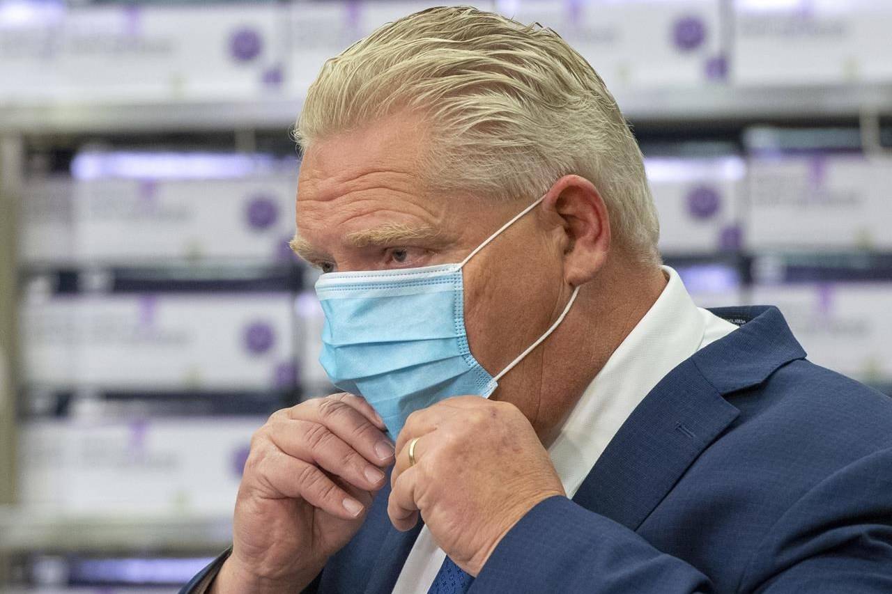 Ontario Premier Doug Ford puts his mask back on during the daily briefing at Humber River Hospital in Toronto on Tuesday November 24, 2020. Ford says he wants a clear delivery date for the province’s share of COVID-19 vaccines, stressing that “the clock is ticking” when it comes to fighting the novel coronavirus. THE CANADIAN PRESS/Frank Gunn