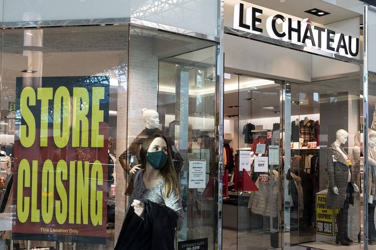 A woman in a face mask exits Le Chateau at Guildford Town Centre in Surrey, B.C., Friday, Dec. 4, 2020. The clothing store is going out of business amid the global COVID-19 pandemic. THE CANADIAN PRESS/Marissa Tiel