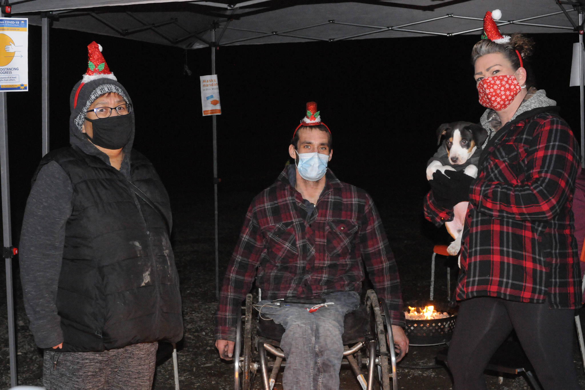 Alice Sam, left, Graham Hughes and Lisa George <ins>(holding Hughes’ puppy Riot</ins>) volunteer at a nighttime ‘pop-up’ warming centre at a city-owned parking lot on Fourth Avenue, Saturday, Dec. 12, 2020. <ins>The warming shelters were a three-night experiment from 6 p.m. to midnight and were set up and taken down each night. </ins> (SUSAN QUINN/ Alberni Valley News)